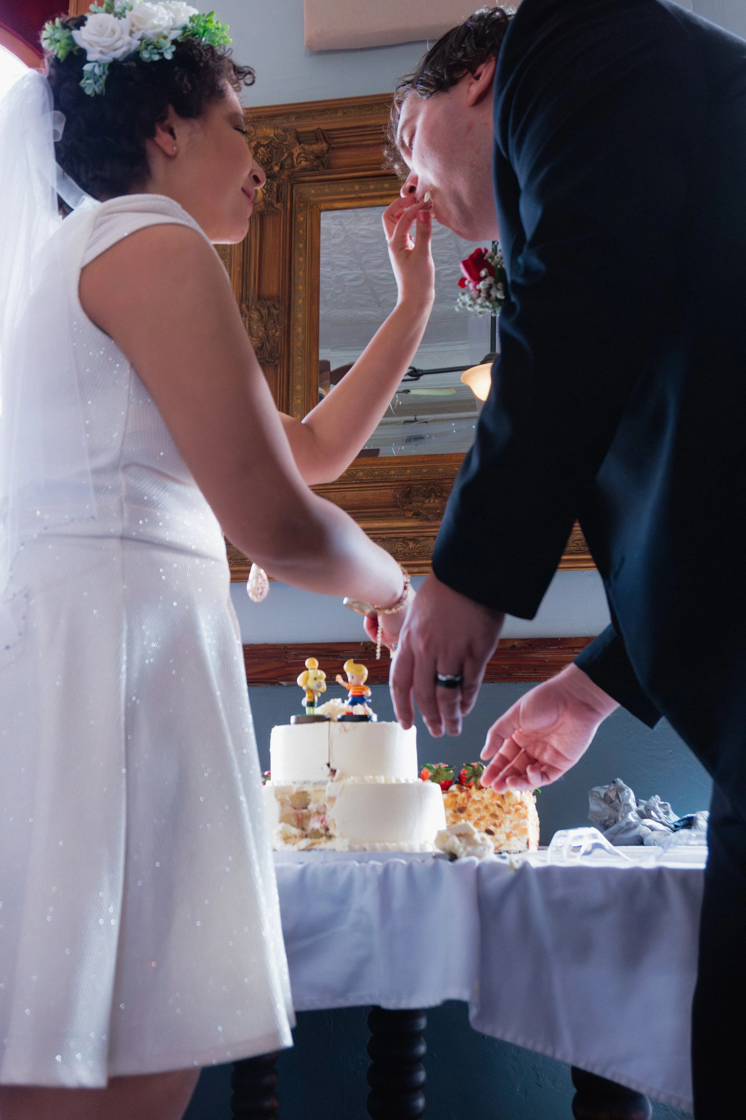 A bride and groom cutting their wedding cake together at their wedding reception.
