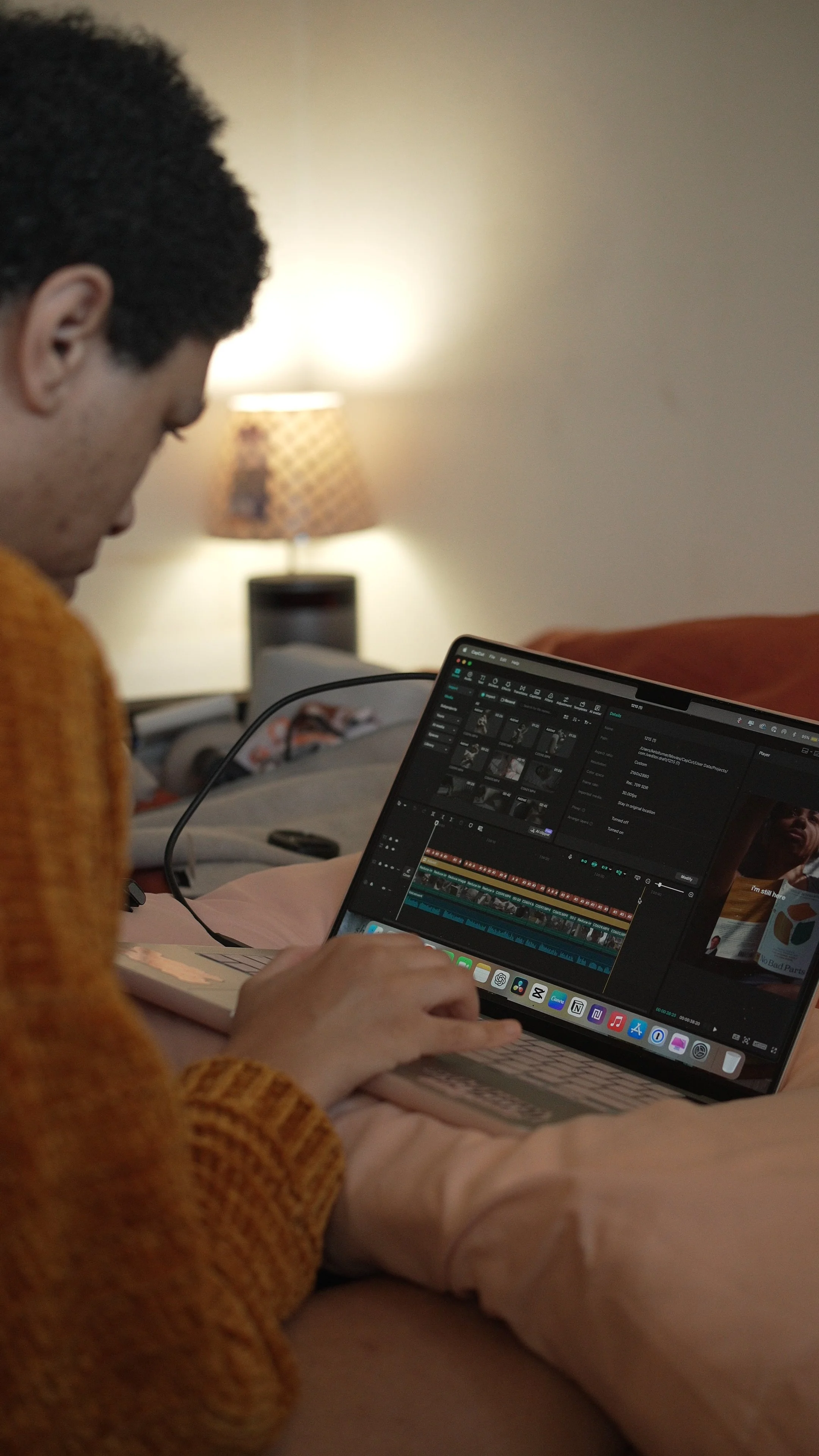 Modern building with large glass window, surrounded by yellow flowers, set against a mountainous landscape.