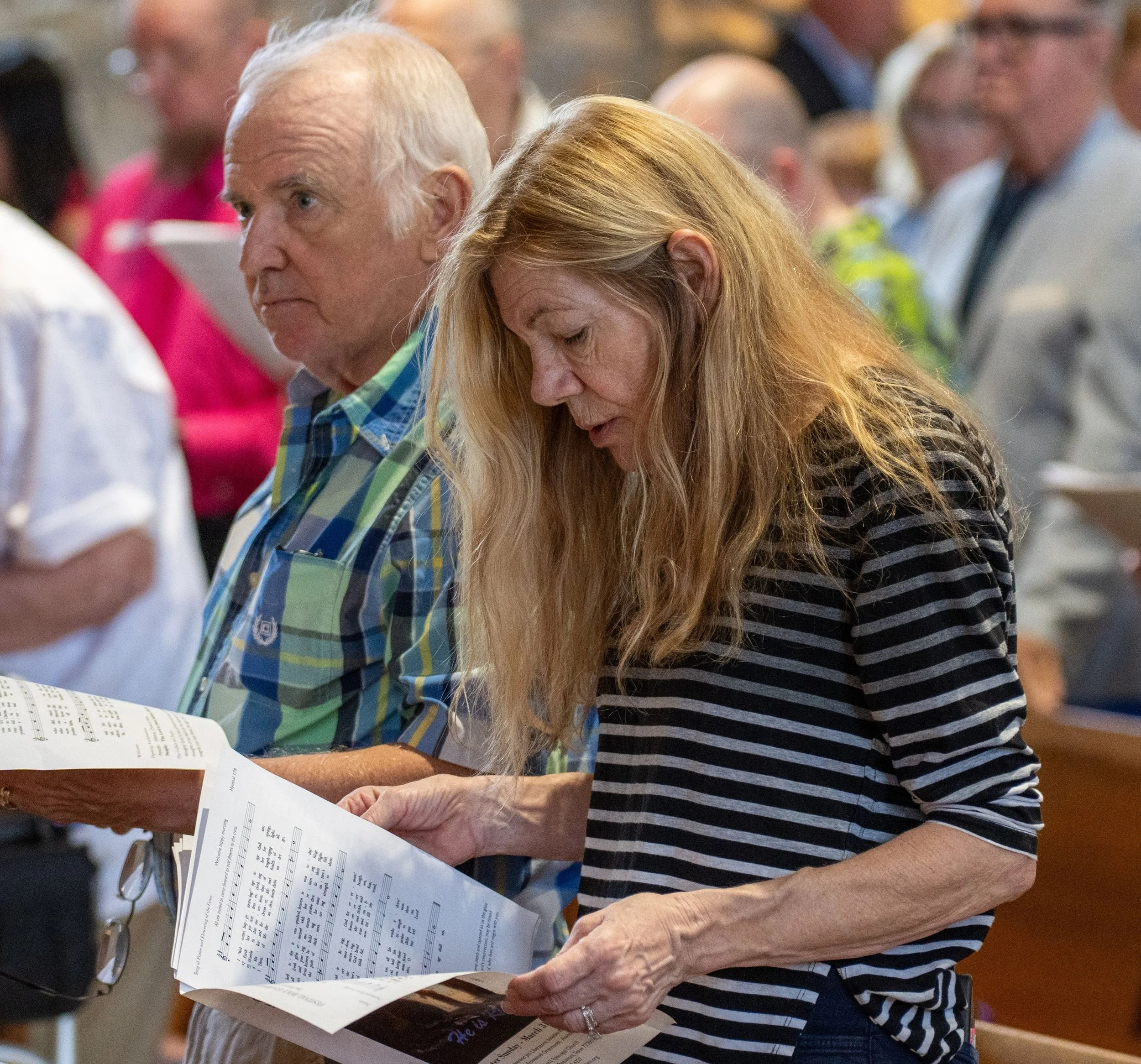 a man and a woman holding papers at church.