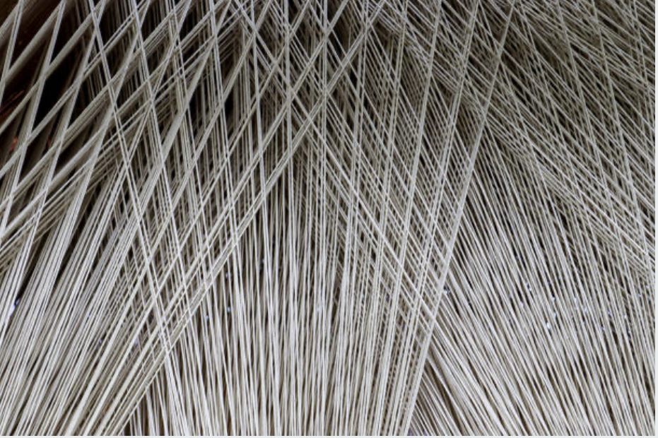 Close-up of beige and brown woven straw or grass material with overlapping fibers.