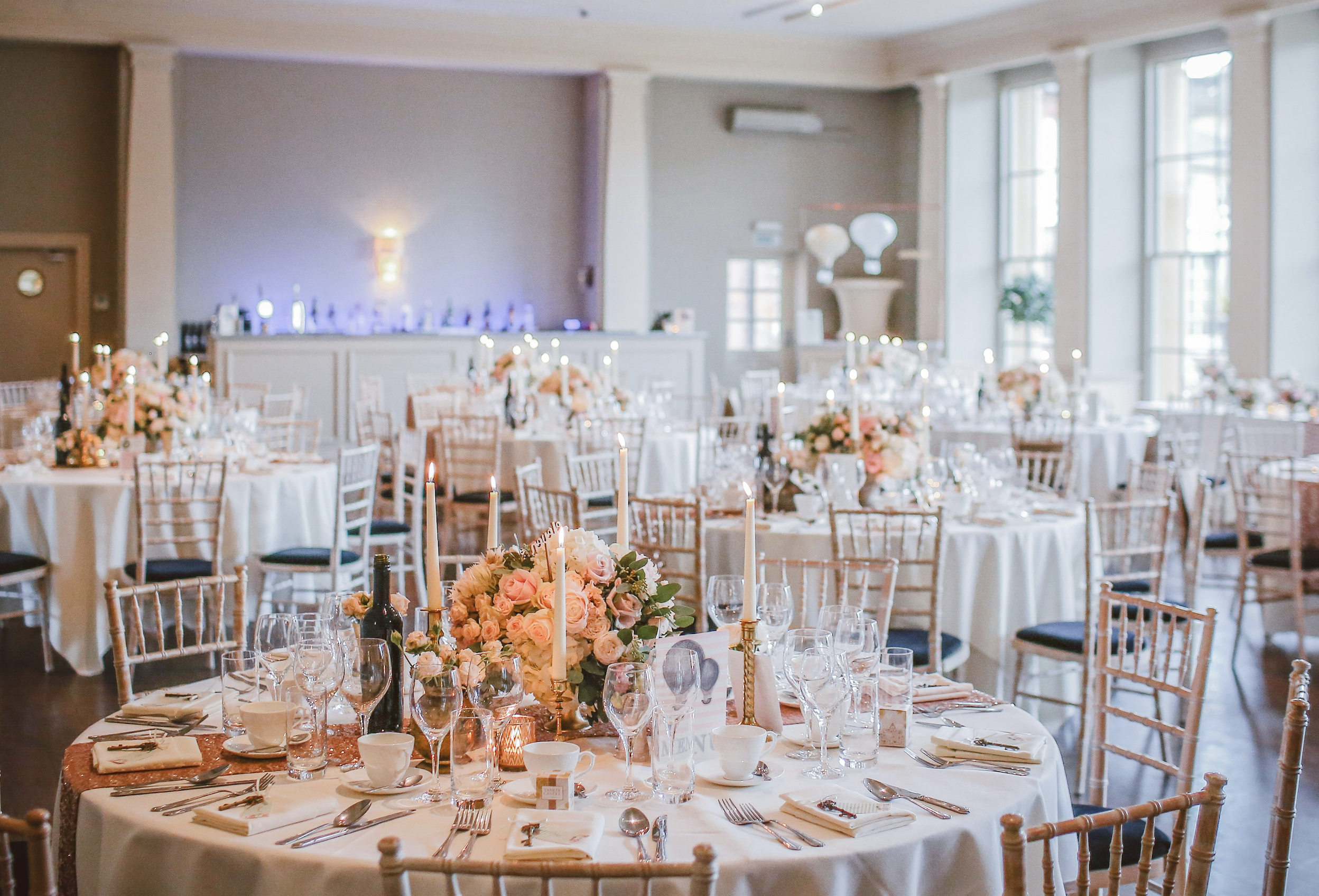 wedding venue inside with white candle and flower table decor