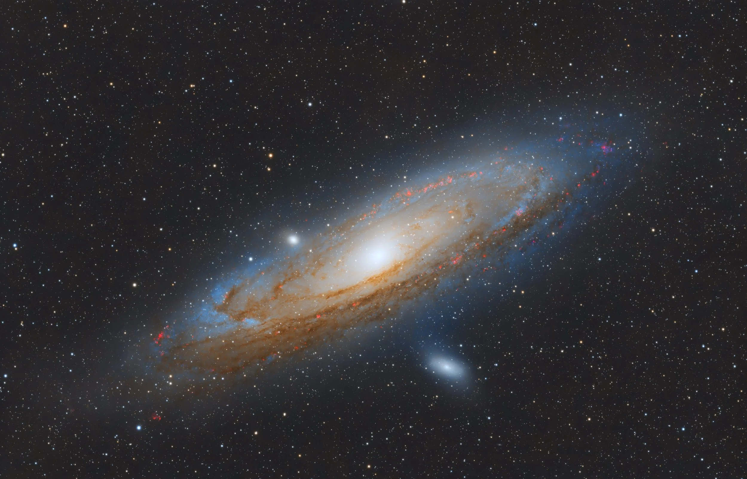 Photo of a galaxy in deep space, showing a bright central core with surrounding spiral arms containing stars and cosmic dust.