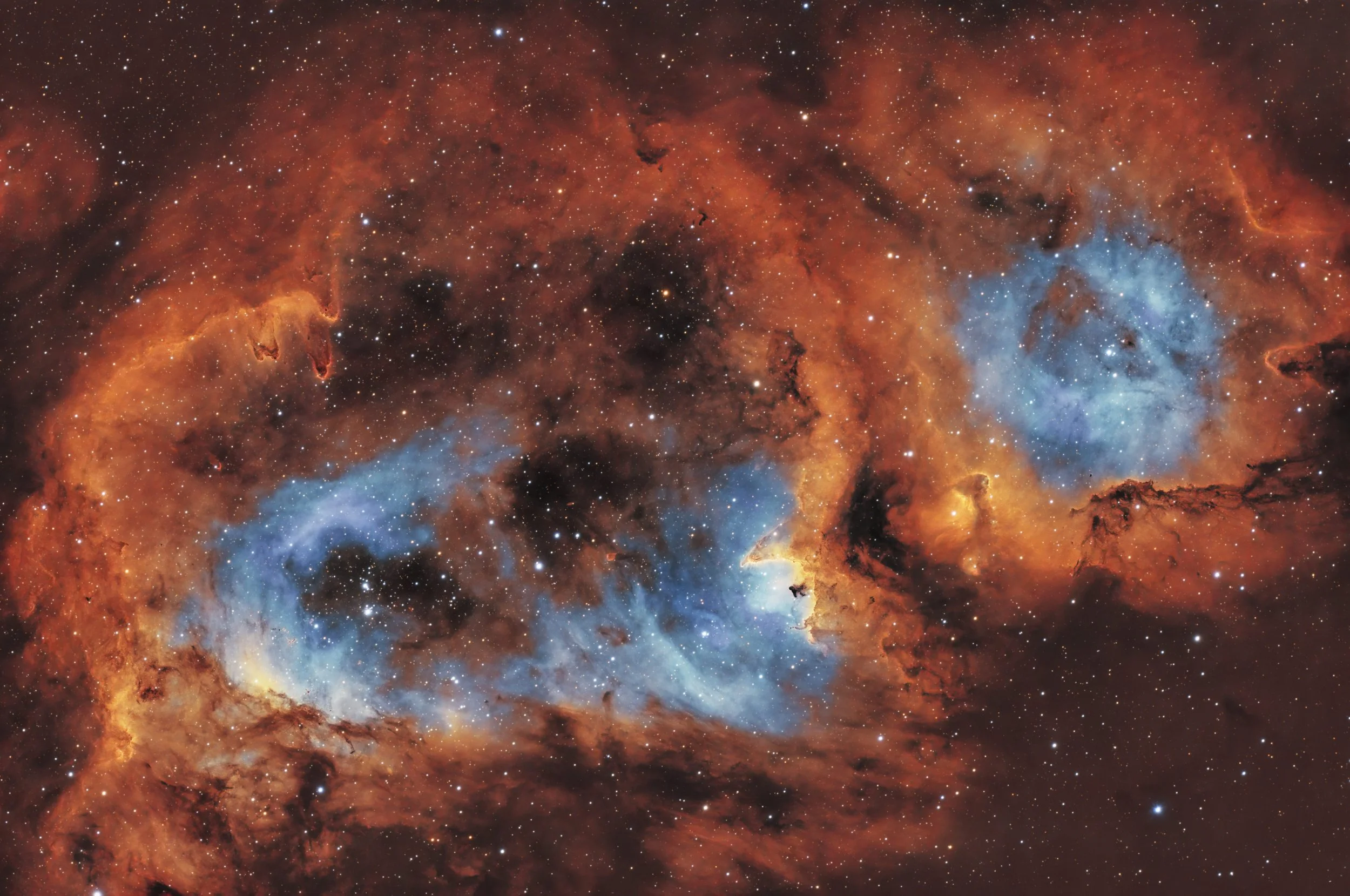 A detailed image of a vibrant nebula in space with orange and blue hues, filled with stars and cosmic clouds.