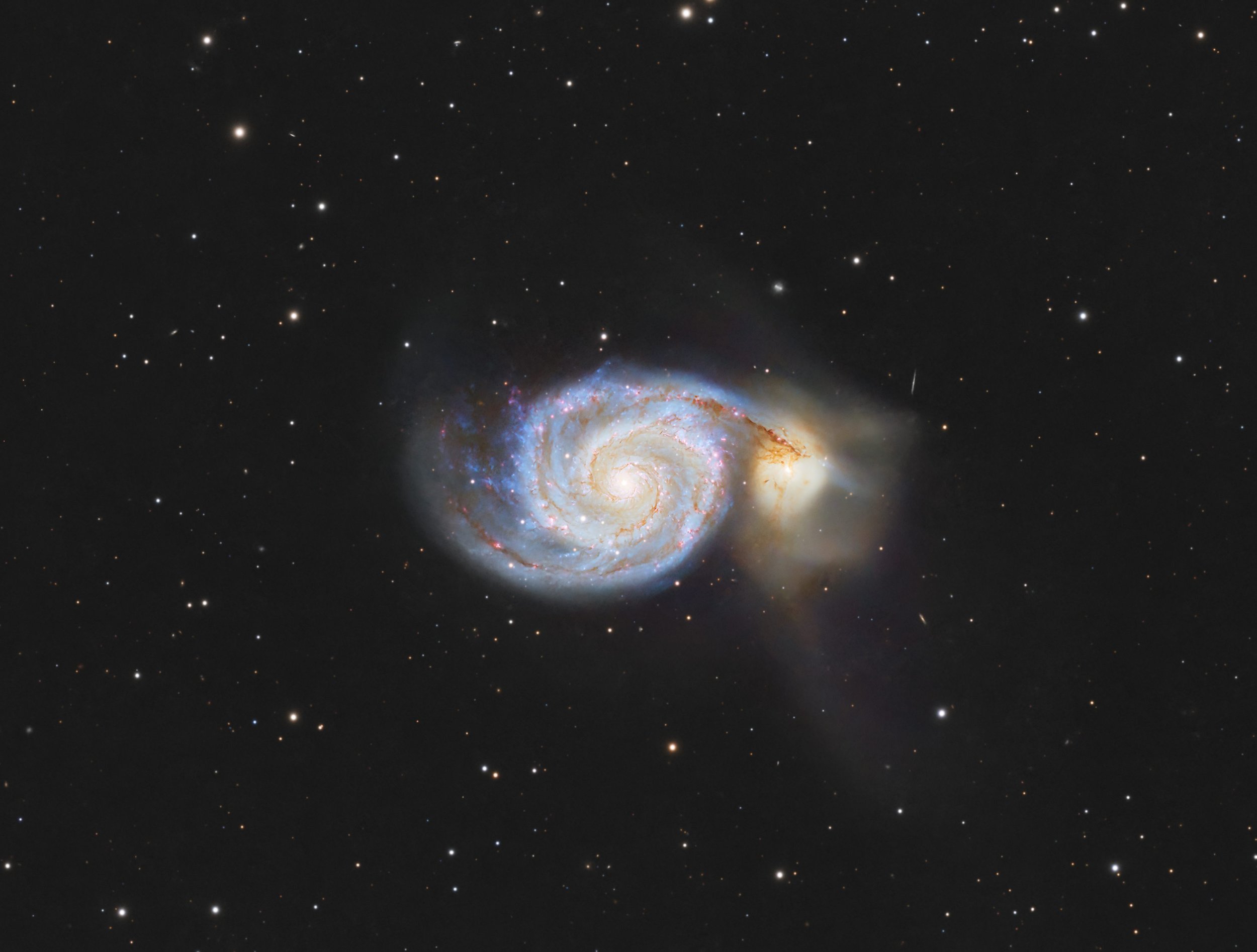 A galaxy in deep space with a bright center and swirling arms, surrounded by numerous stars.