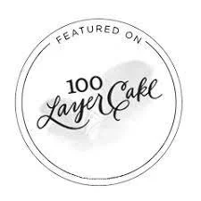 Circular logo with text: 'Featured on 100 Layer Cake'.