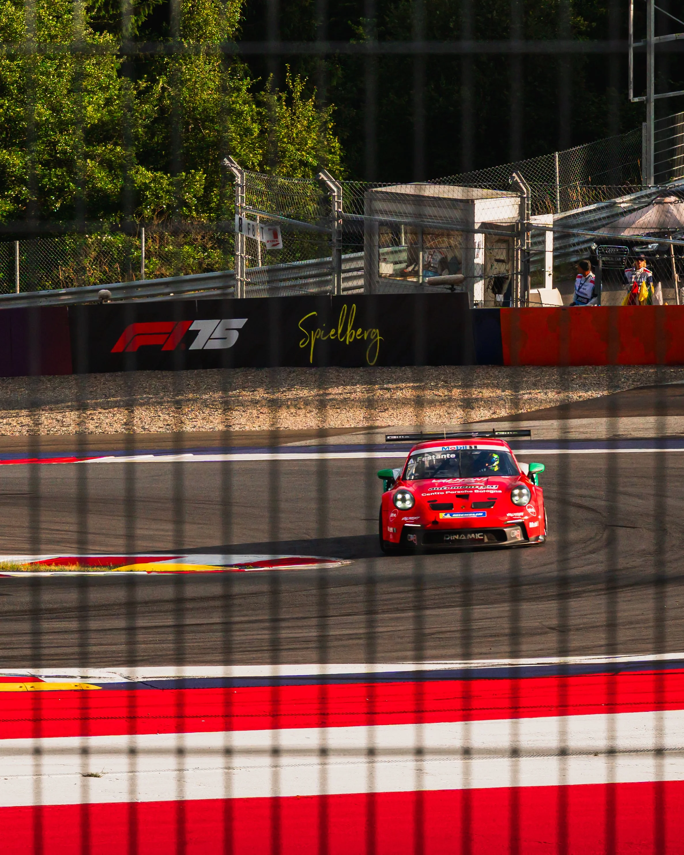 Ein rotes Rennauto fährt auf einer Rennstrecke bei einem Autorennen.