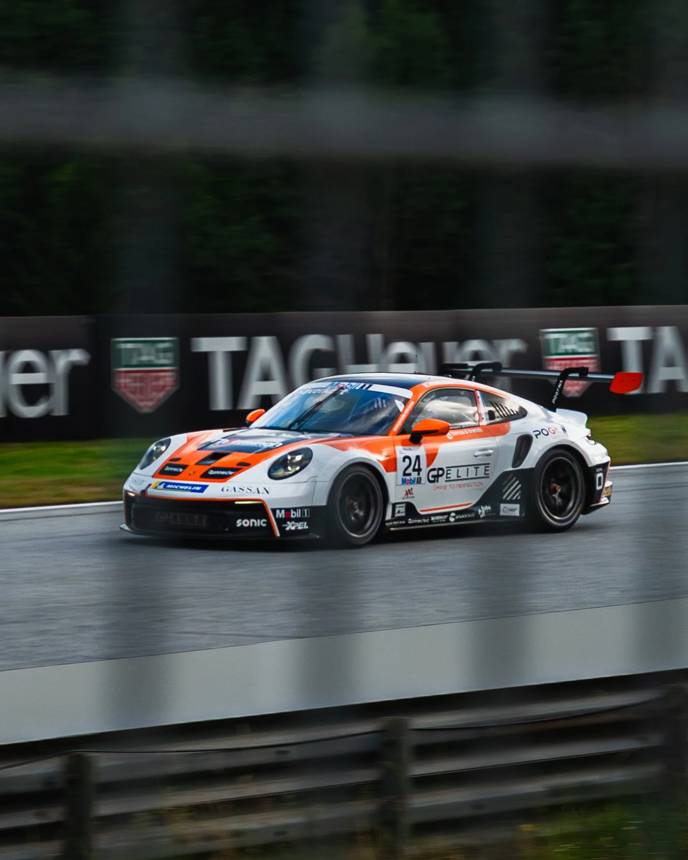 Ein Rennwagen auf einer Rennstrecke während eines Regenschauers.