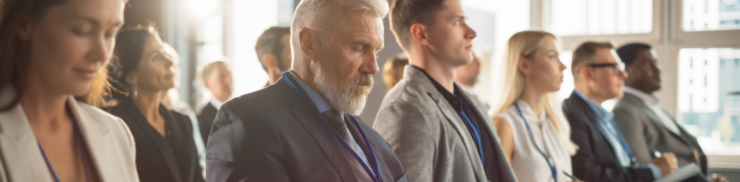 Group of diverse professionals attending a conference or seminar, seated and listening attentively.