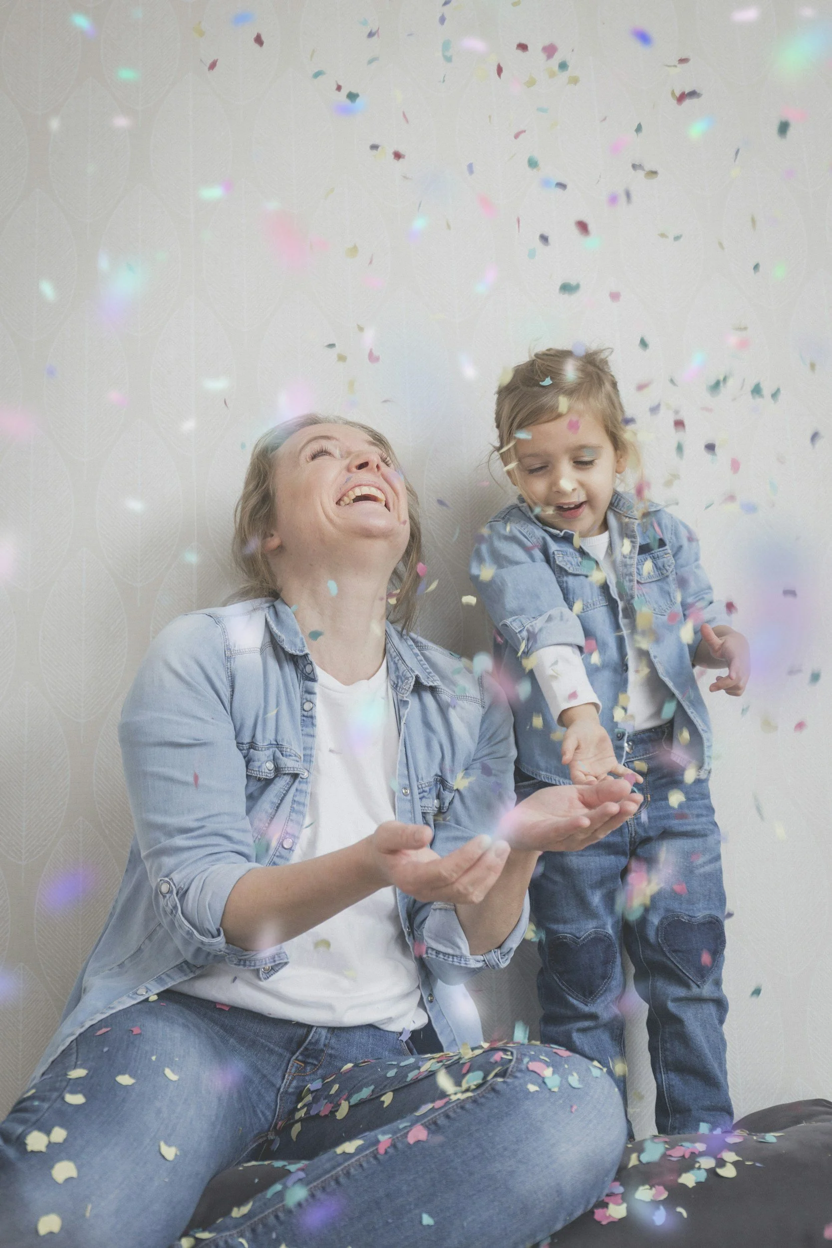 Mother and daughter celebrating together as they throw confetti, representing confidence, resilience, and a growth mindset in children.