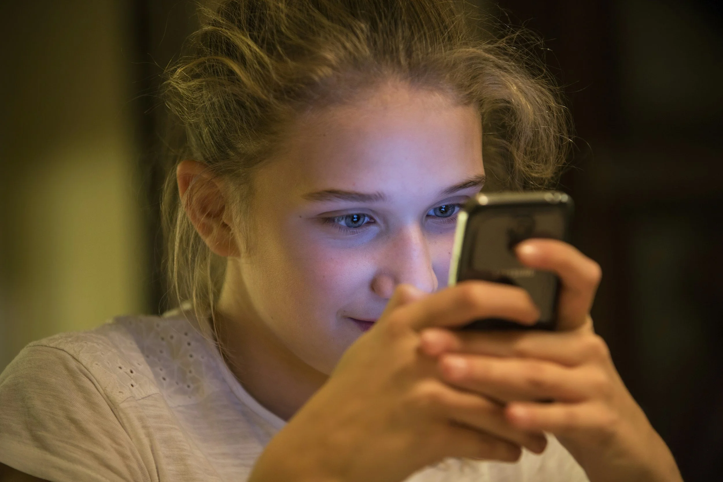 Teenager using a smartphone to send a text message, illustrating how digital communication helps teens stay connected with their families.