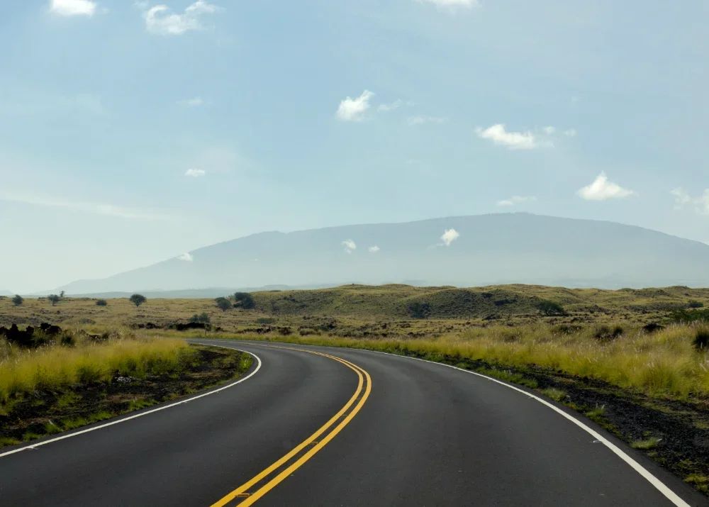 Saddle Road winding into the distance with Maunakea on the horizon
