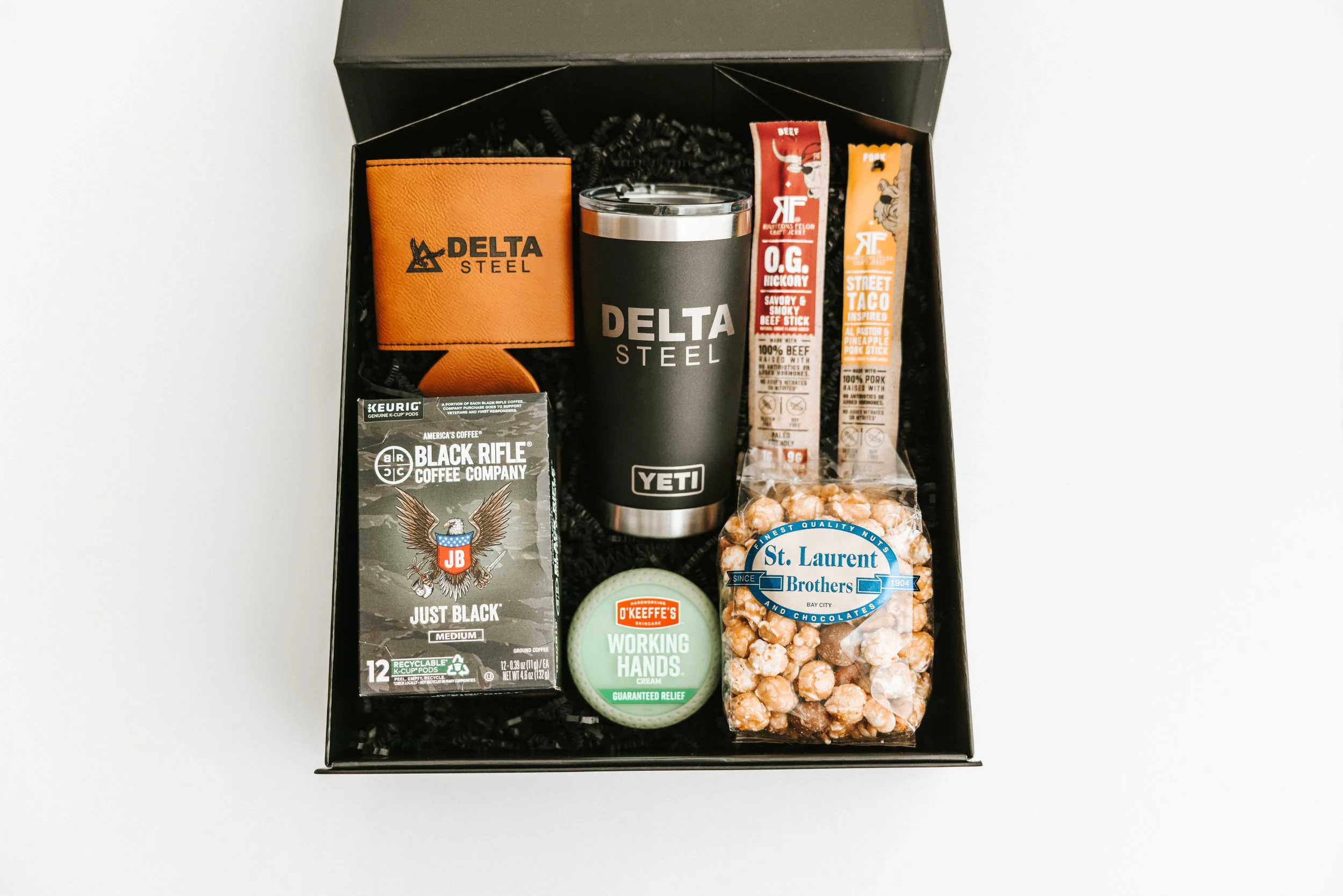 Gift box with coffee, snacks, grooming cream, and a wallet.