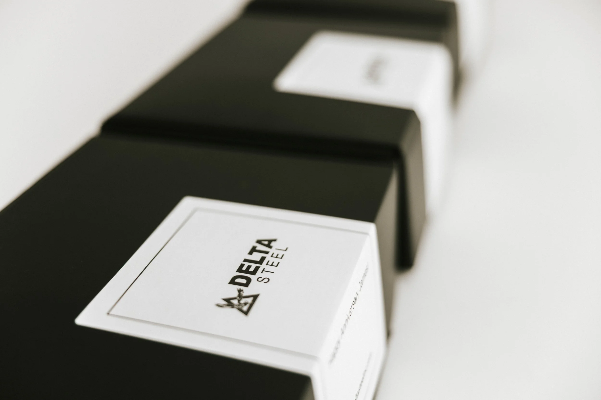 Row of black office chairs with white tags on the backrest reading Delta Steel.