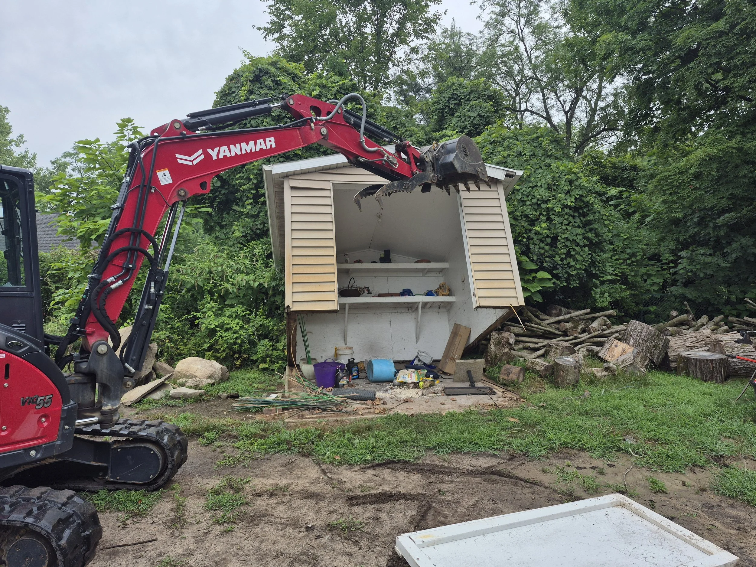 Small storage shed being professionally demolished by skilled crew.