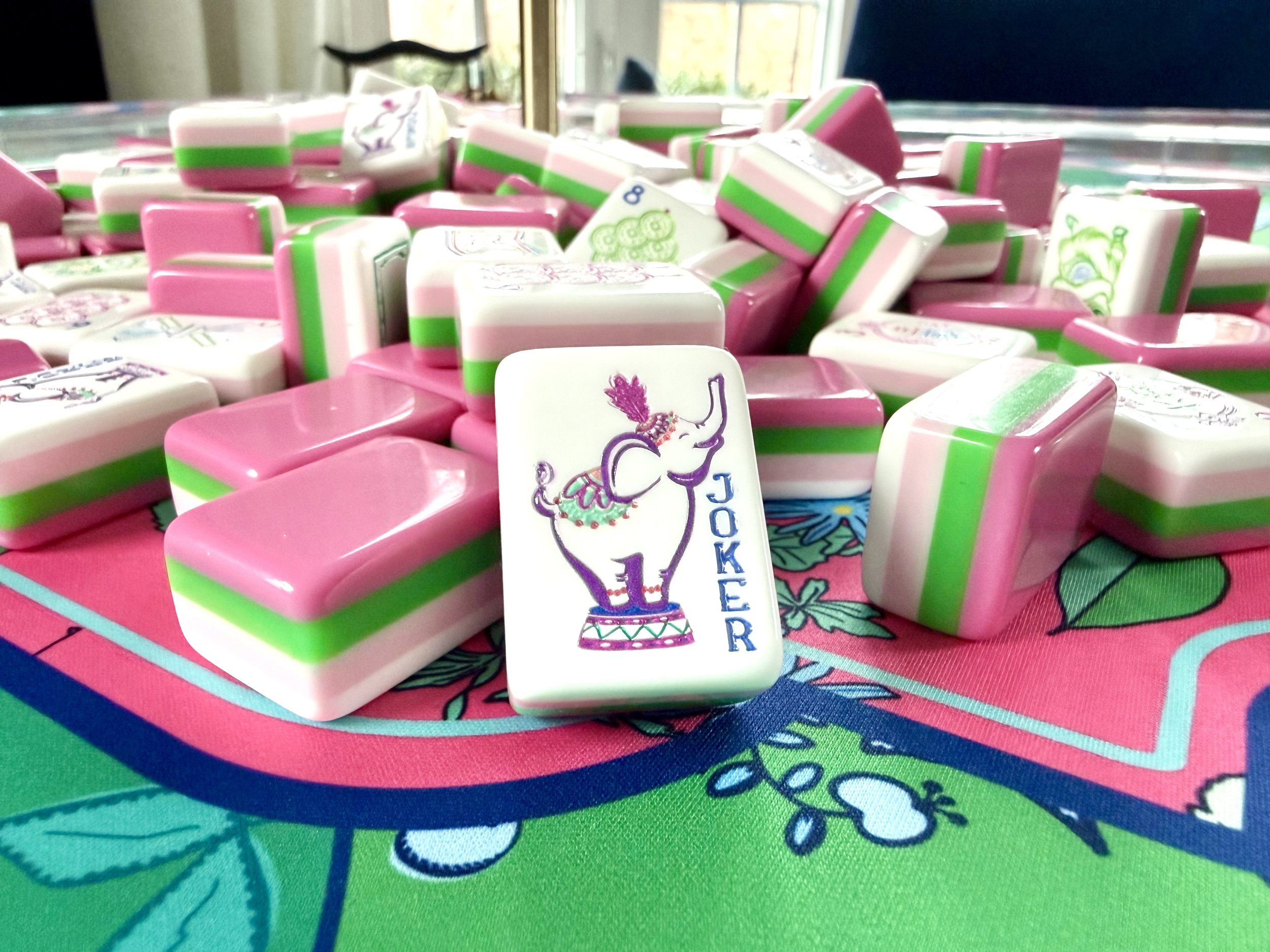 Colorful domino pieces with a peacock design on one piece, scattered on a game board.