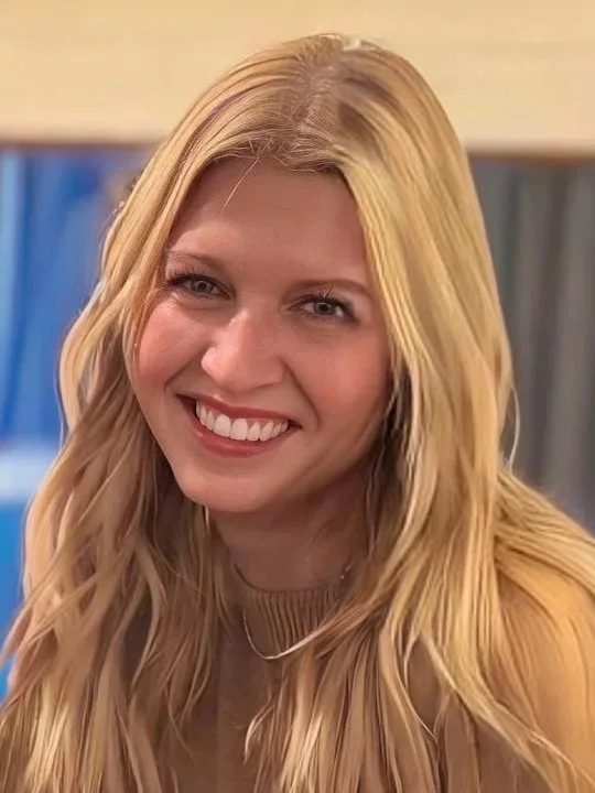 A young woman with long blonde hair smiling at the camera.