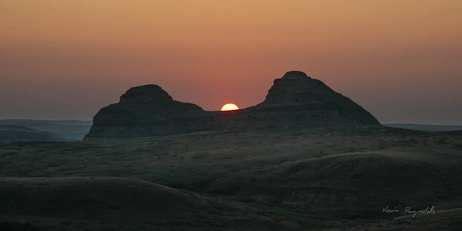 Sun sets behind a badlands hoodoo