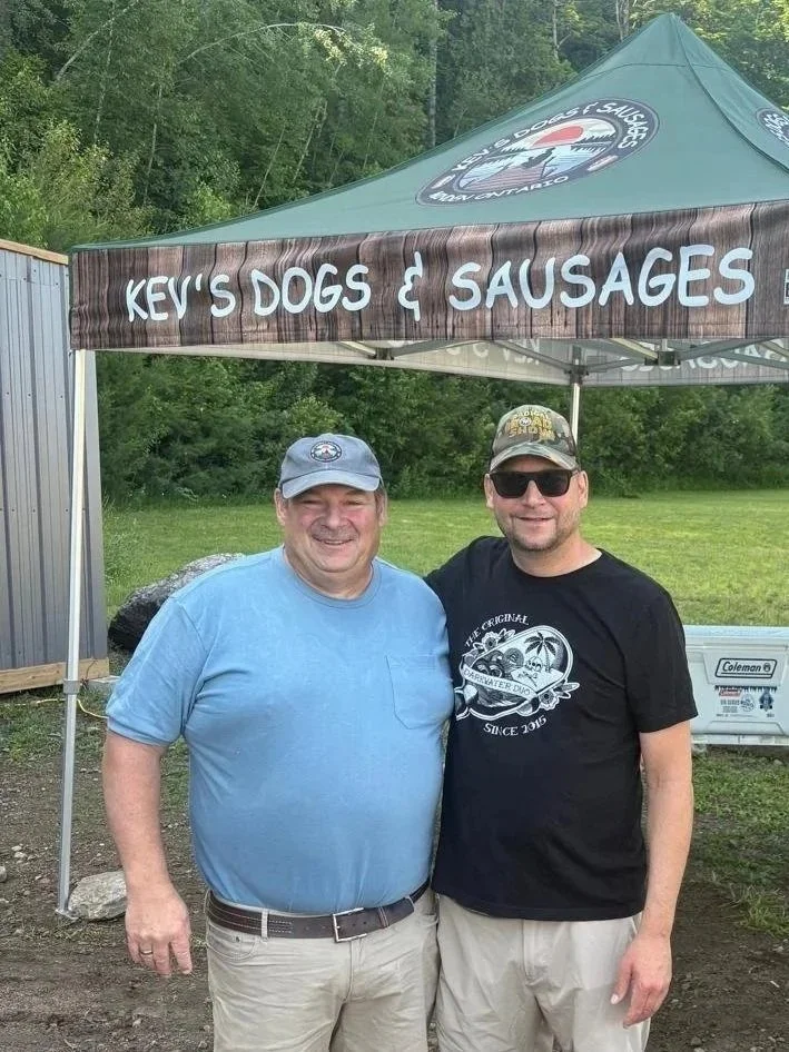 Kev with customer with canopy grass and bushes in the background.