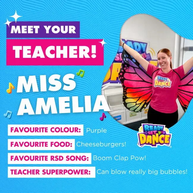A young woman wearing a pink shirt with a butterfly wing costume, smiling with arms raised in a classroom decorated with "Ready Set Dance" logo. Text on the image introduces Miss Amelia, a dance teacher, with details about her favorite color, food, song, and superpower.