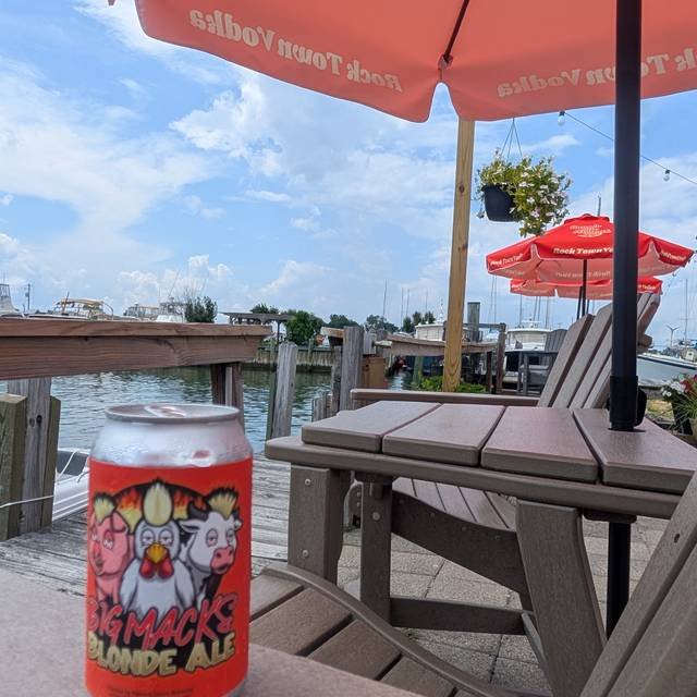 Photo of the dock view from Big Mack's Kitchen & Bar with a custom beer can featuring the Big Mack's Kitchen logo