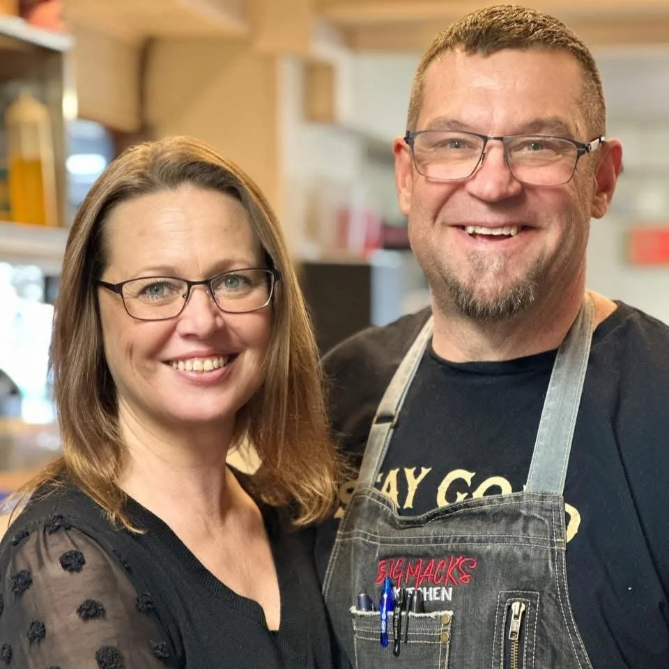 Portrait of Chef Chris Mack and his wife Jen Mack smiling in their restaurant, Big Mack's Kitchen