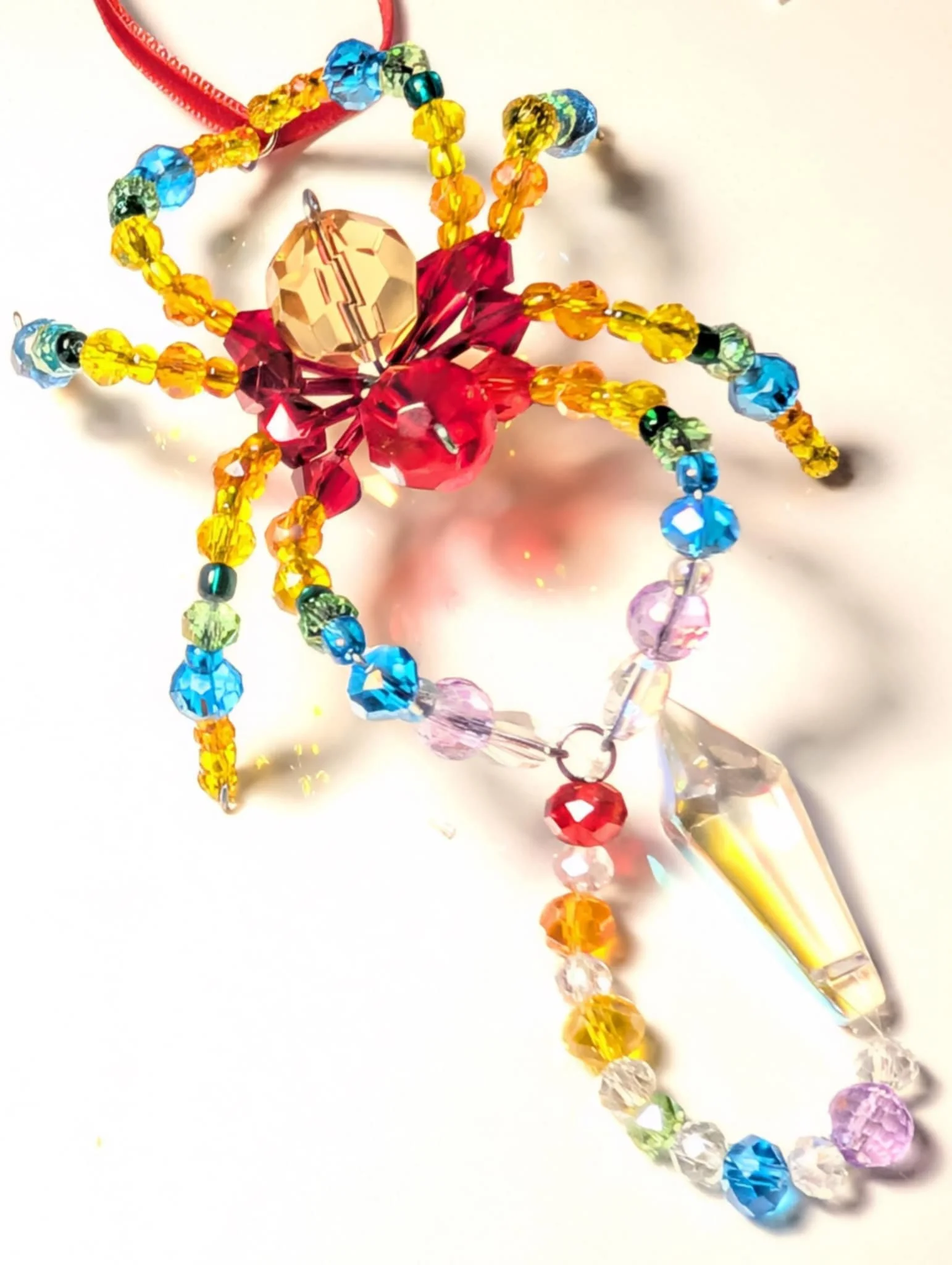 Colorful beaded crystal ornament with a large crystal drop, arranged in a flower shape with multiple beaded strands.