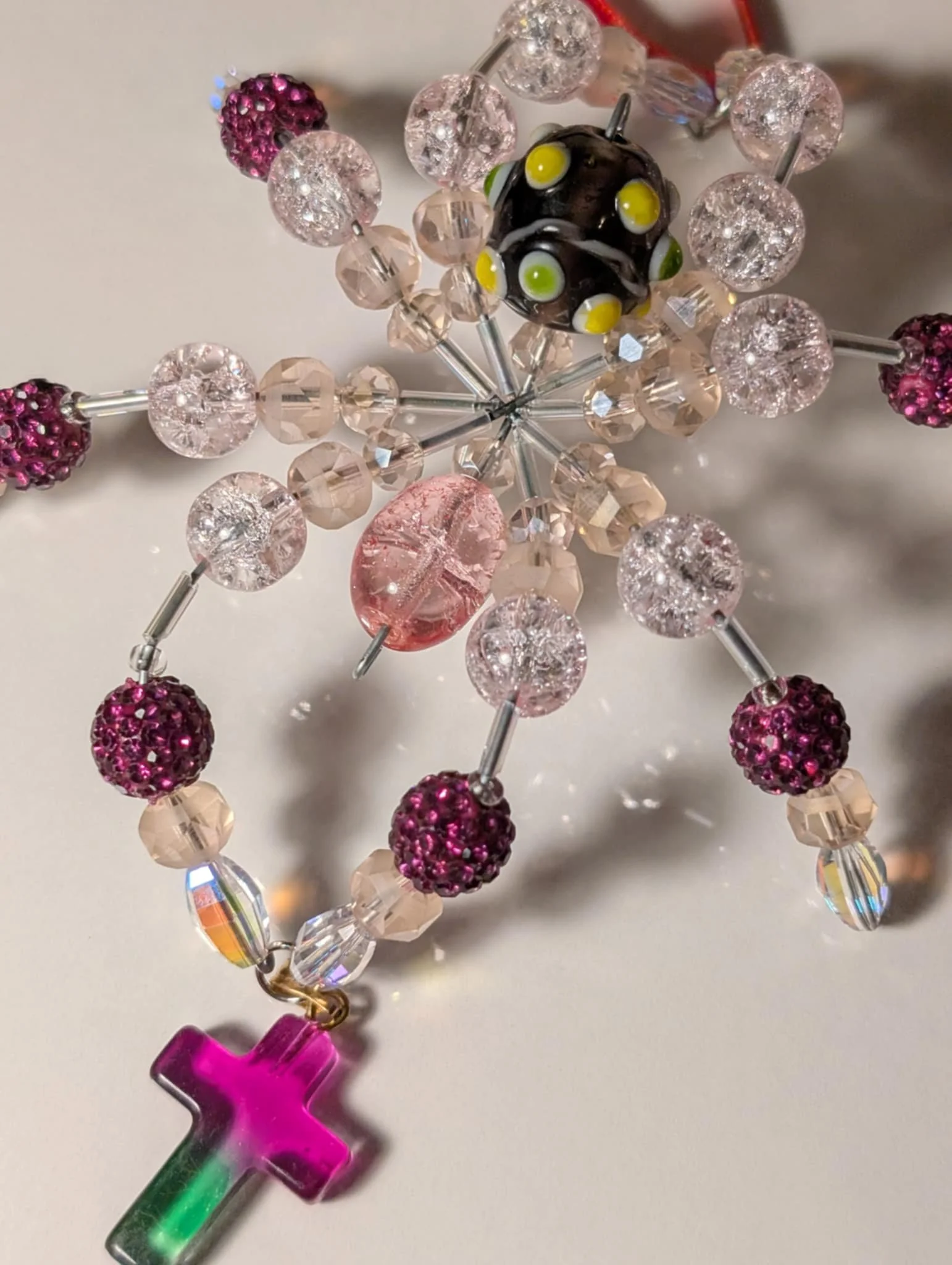 Beaded cross keychain with multicolored beads and a pink and green acrylic cross pendant.