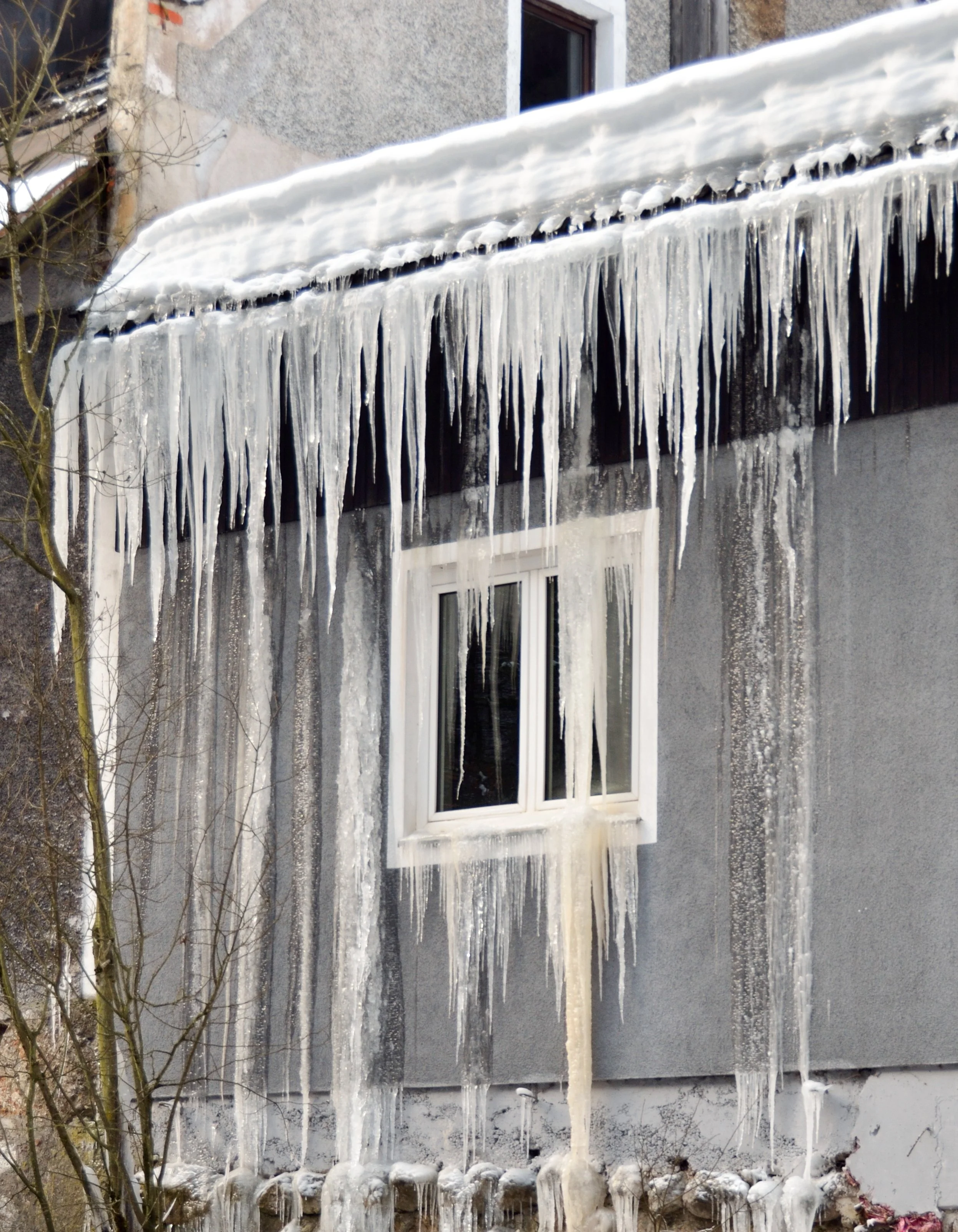 Ice dam and roof leakage along a snowy roof edge