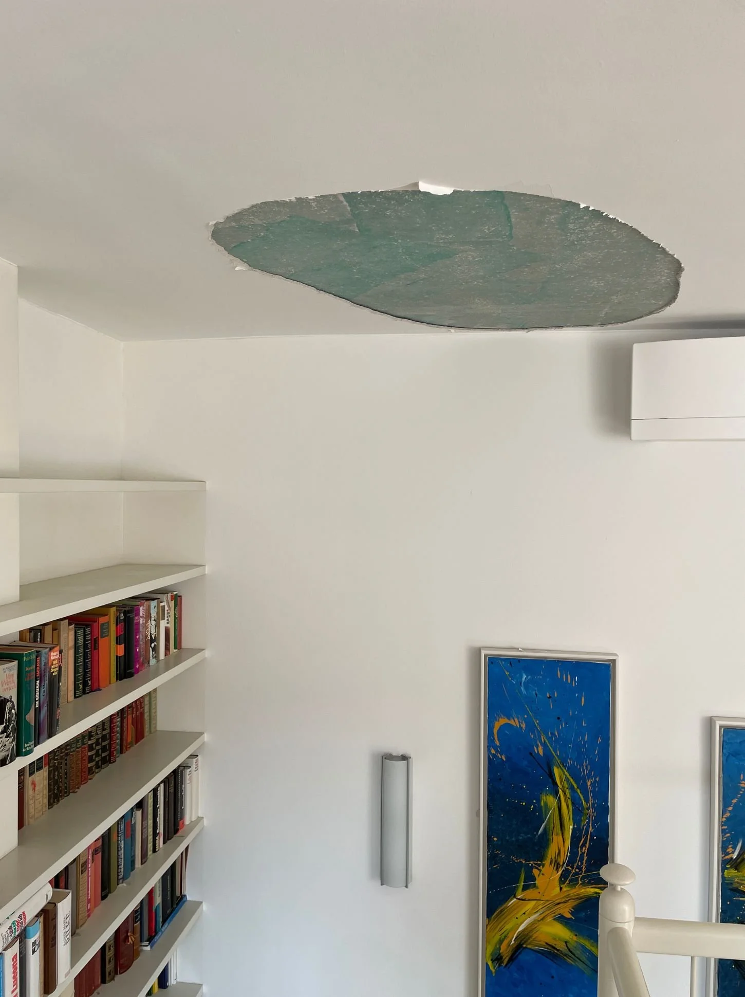 Wasserschaden an der Decke im Stiegenhaus mit sichtbarer Öffnung vor Sanierung und Wiederherstellung im Wohnbereich