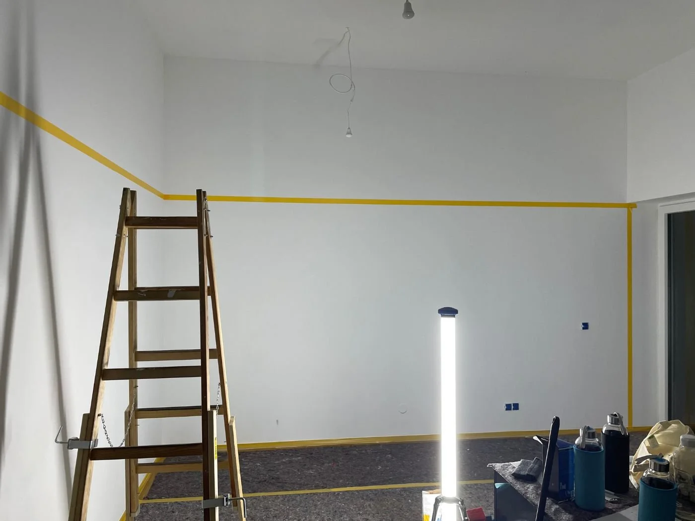 Wohnraum während der Renovierung mit markierter Farbabgrenzung und vorbereiteter Wandgestaltung für ein individuelles Farbkonzept