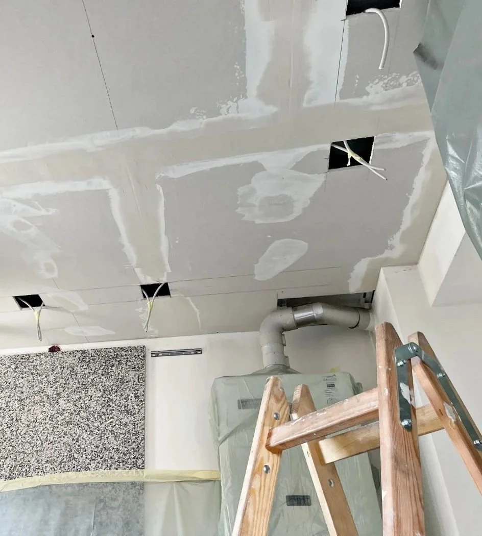 Spachtelarbeiten einer Trockenbaudecke als Vorbereitung für den Einbau von Deckenspots