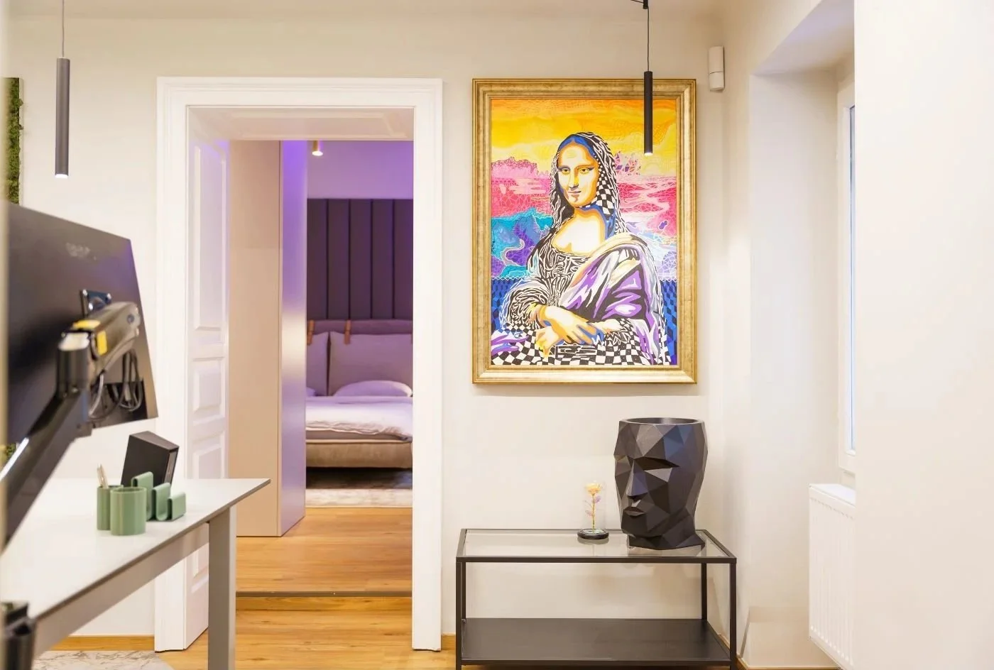 Modernes Raumkonzept mit Homeoffice im Schlafzimmer: Arbeitsplatz mit Monitor und ordentlichem Tisch im Vordergrund, Blick ins elegante Schlafzimmer im Hintergrund - nahtloses Design und Ästhetik, offen und schick, Renovierung von Paddy Artist Design