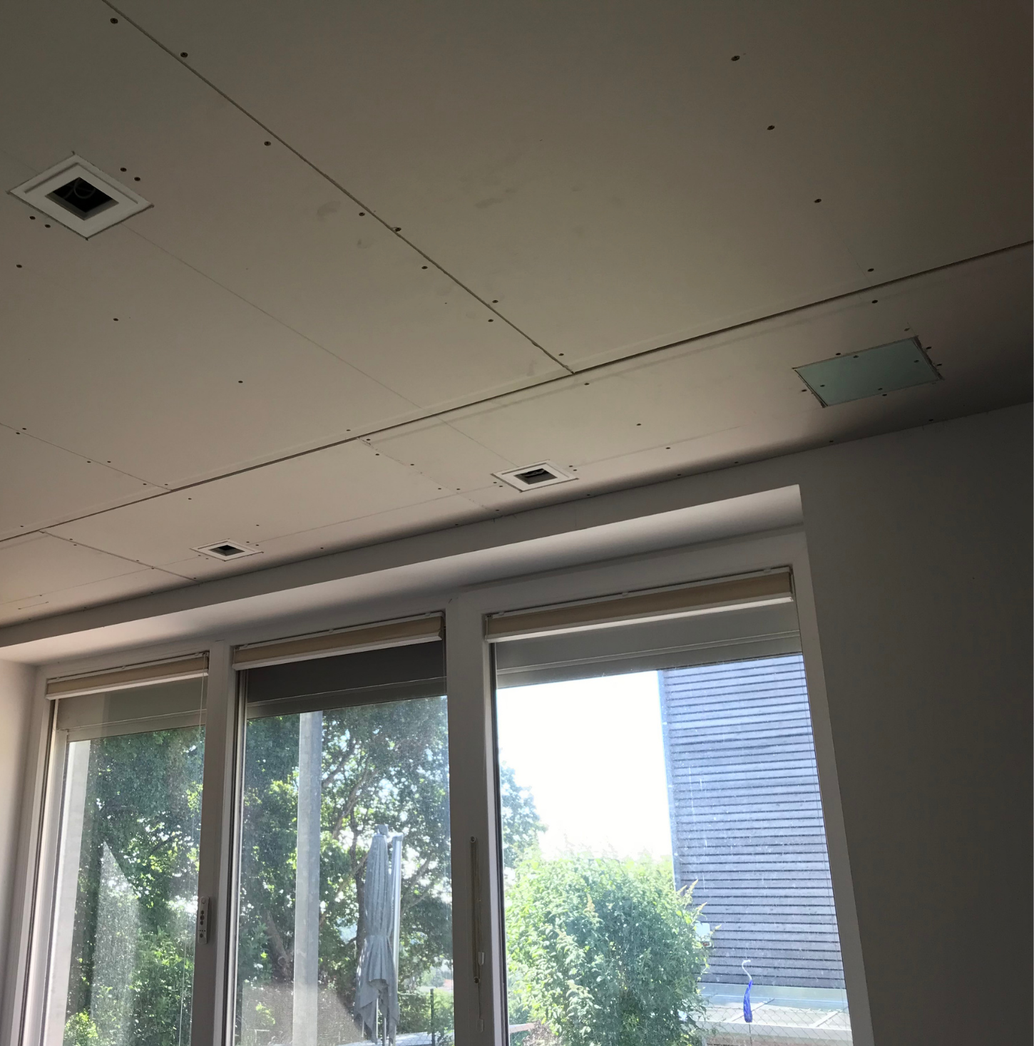 Deckenumbau im Wohnzimmer mit abgehängter Decke, Innenausbau, Fensterfront und Vorbereitung für integrierte Beleuchtung während der Umbauphase