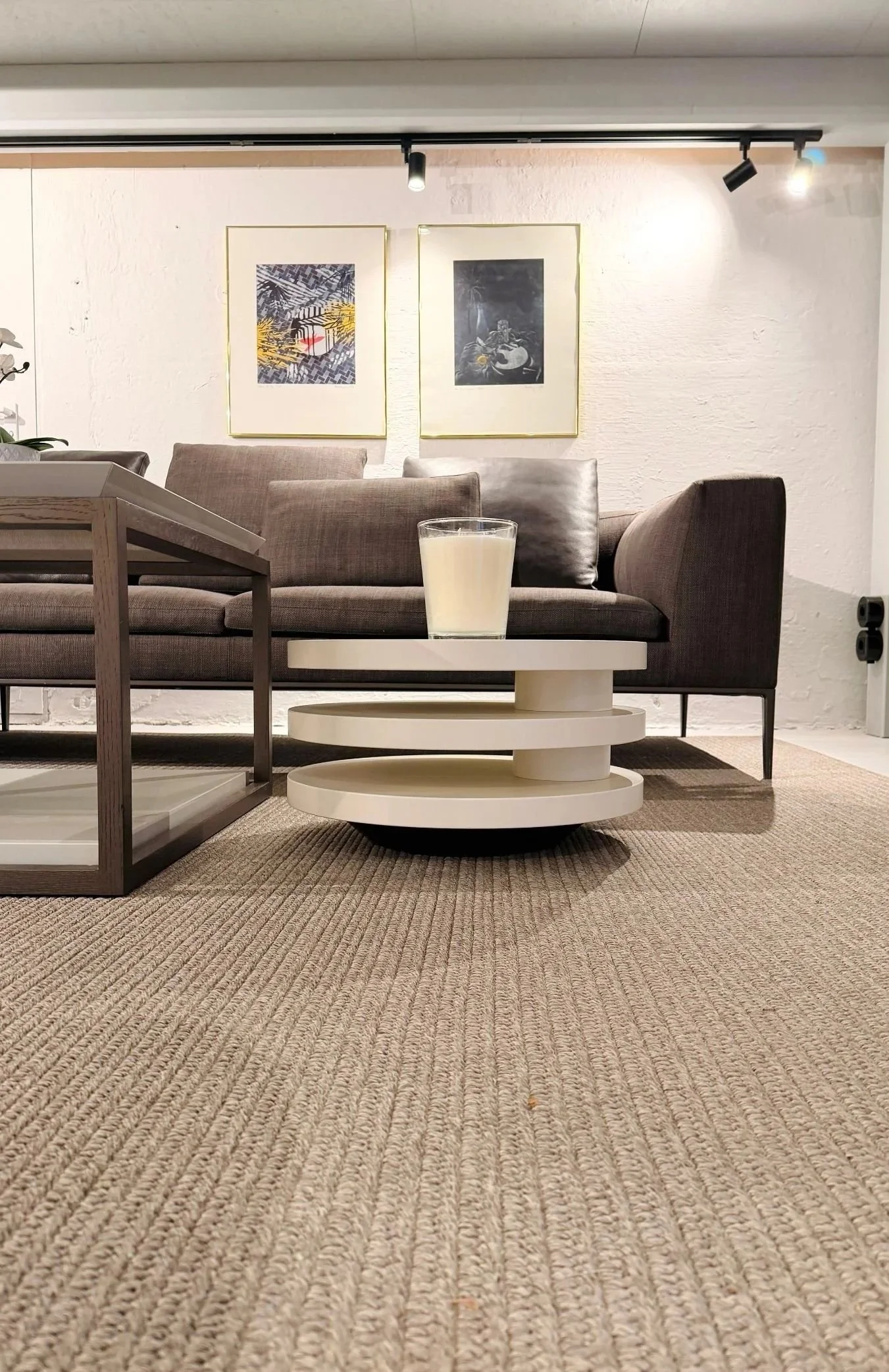 Heller Wohnbereich mit Sofa, rundem Couchtisch und großem Teppich