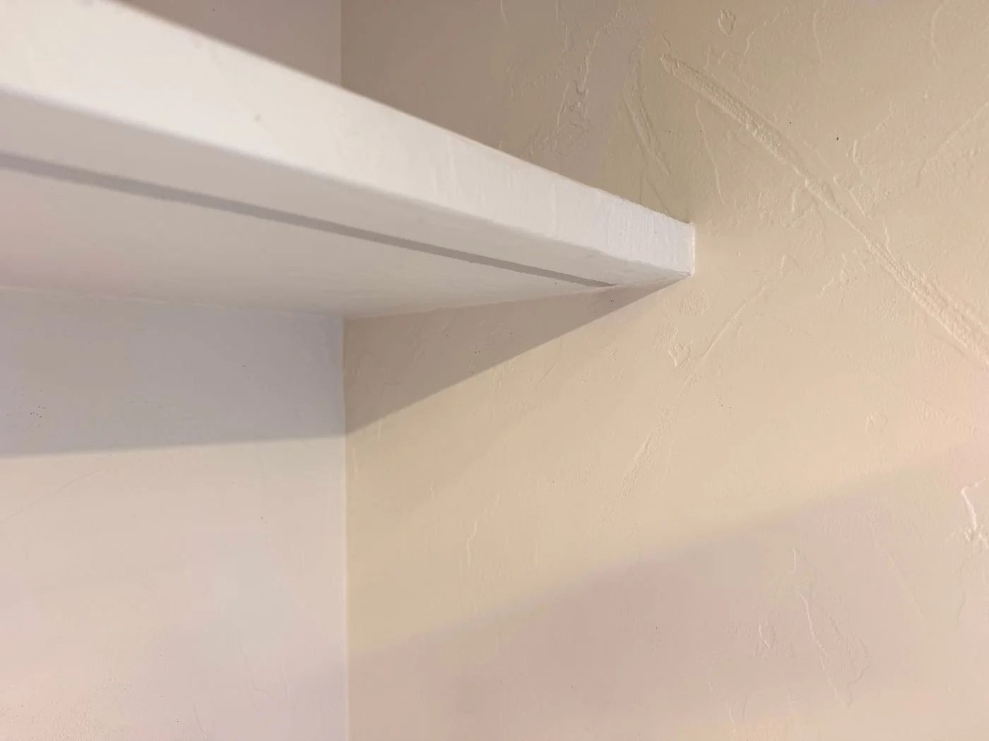 Detailaufnahme einer weißen fugenlosen Wandoberfläche mit dezenter Struktur