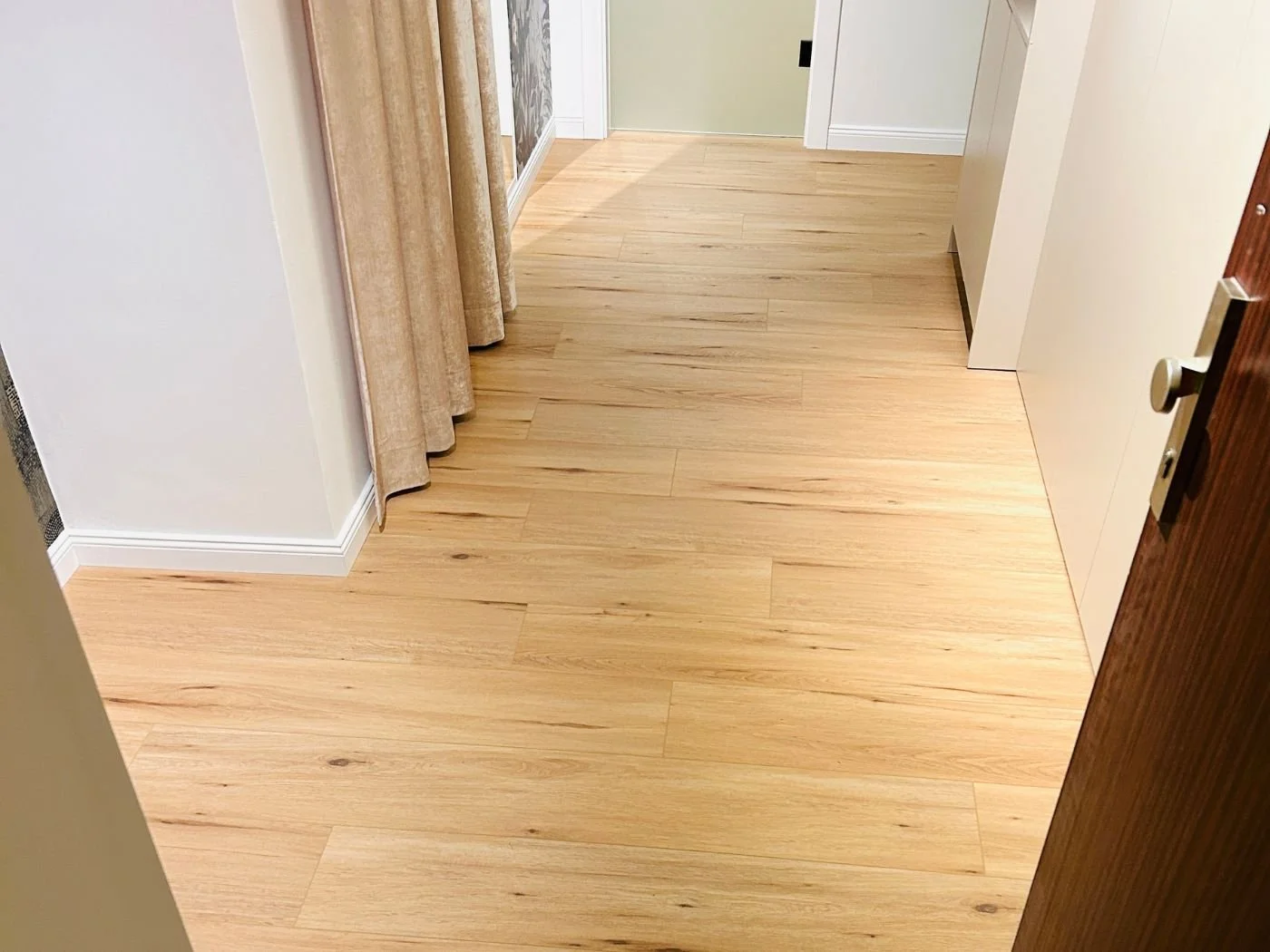 Neu verlegter Vinylboden im Flur einer Wohnung mit heller Holzoptik, sauberer Verlegung und freundlicher Wirkung