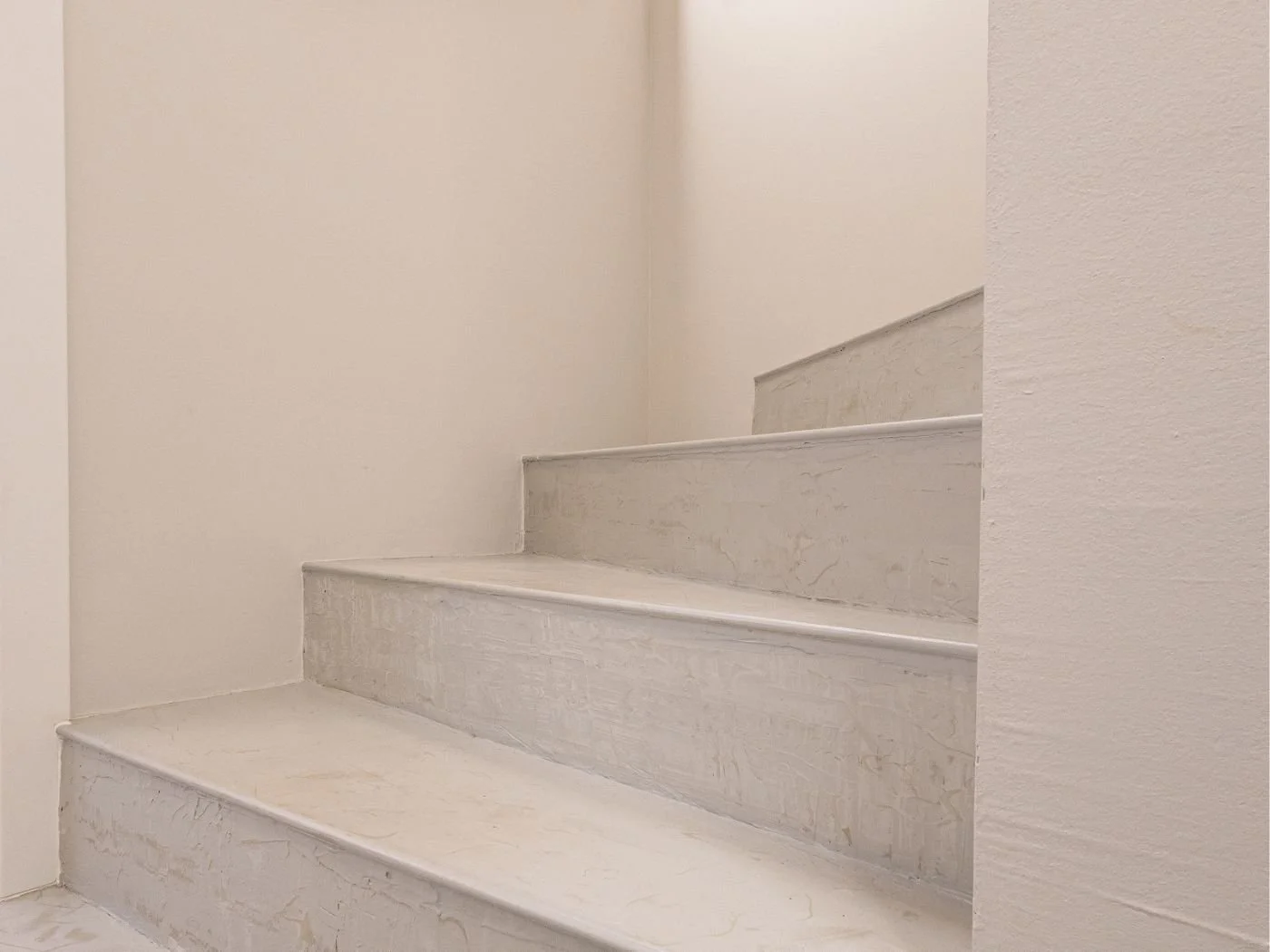 Detail einer fugenlos beschichteten Treppe in heller Marmoroptik