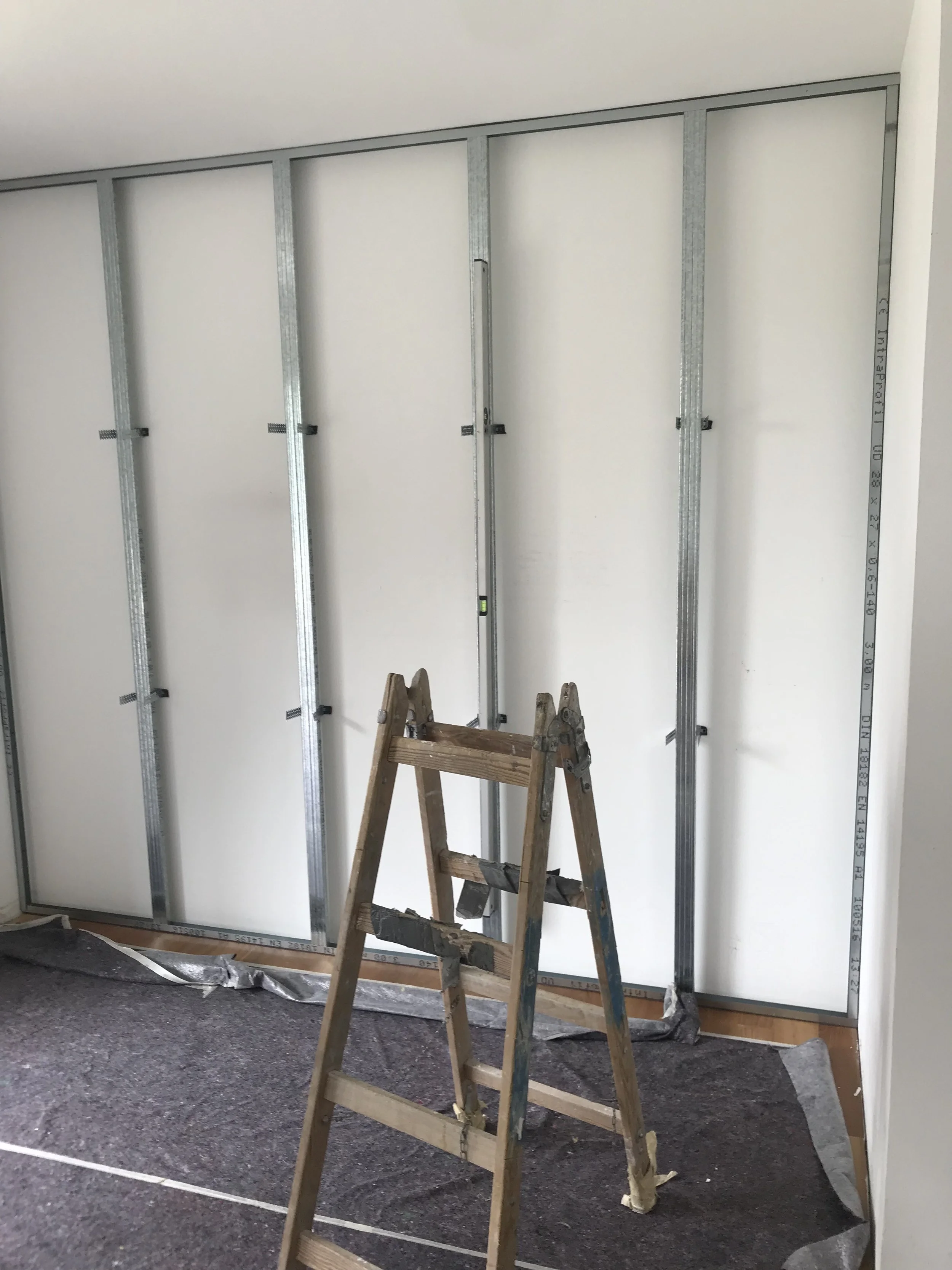 Trockenbau: Ständerwand aus Metallprofilen mit Leiter im Raum - Vorbereitung für Innenausbau und Renovierung, Paddy Artist Raumausstattung und Interior Design, Wien, Österreich