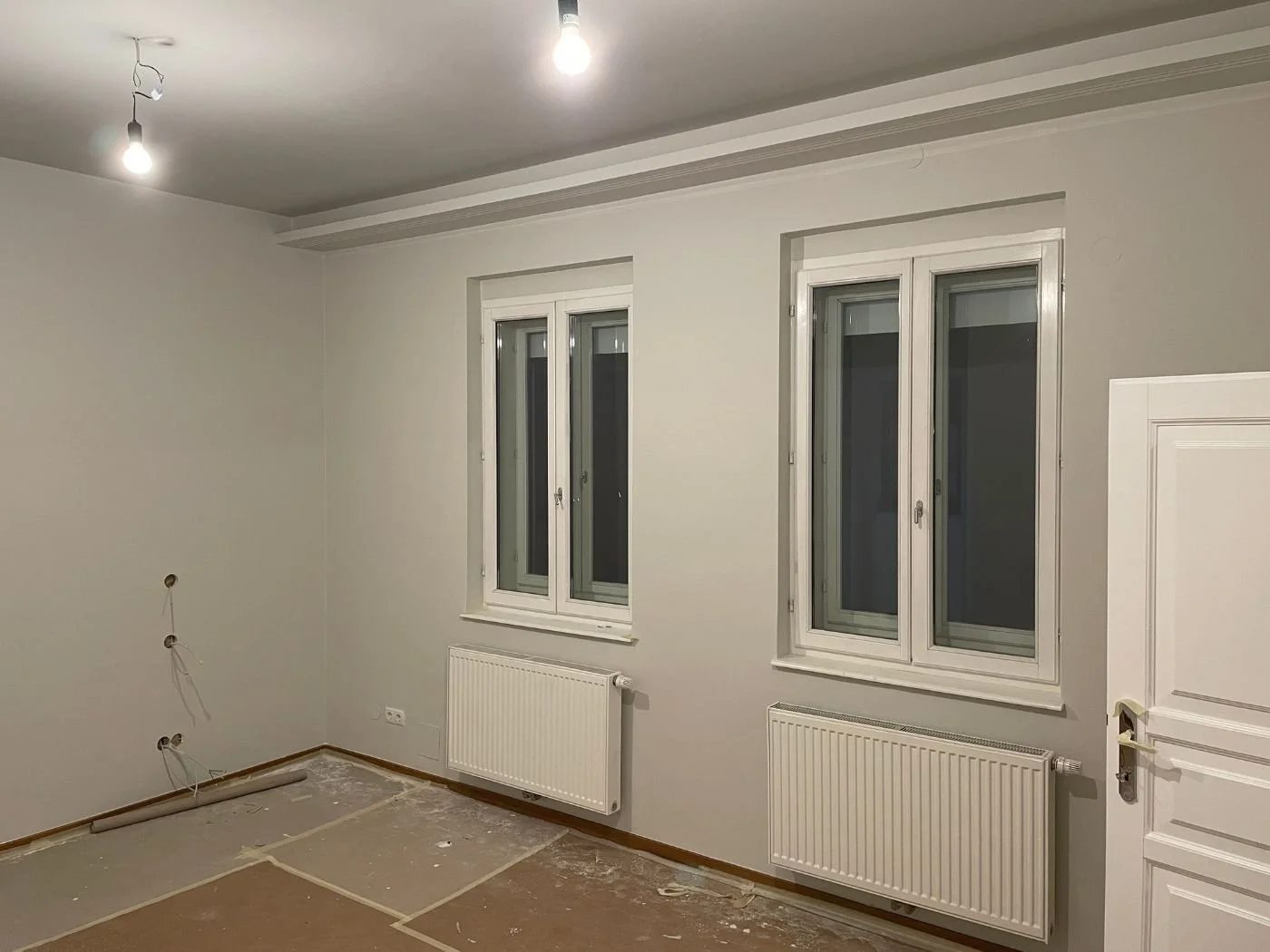 Schlafzimmer vorher bei Wohnungsrenovierung im Altbau: frisch gespachtelte und grau gestrichene Wand, Konstruktion für indirekte LED-Beleuchtung - moderne Renovierung der Paddy Artist Design GmbH