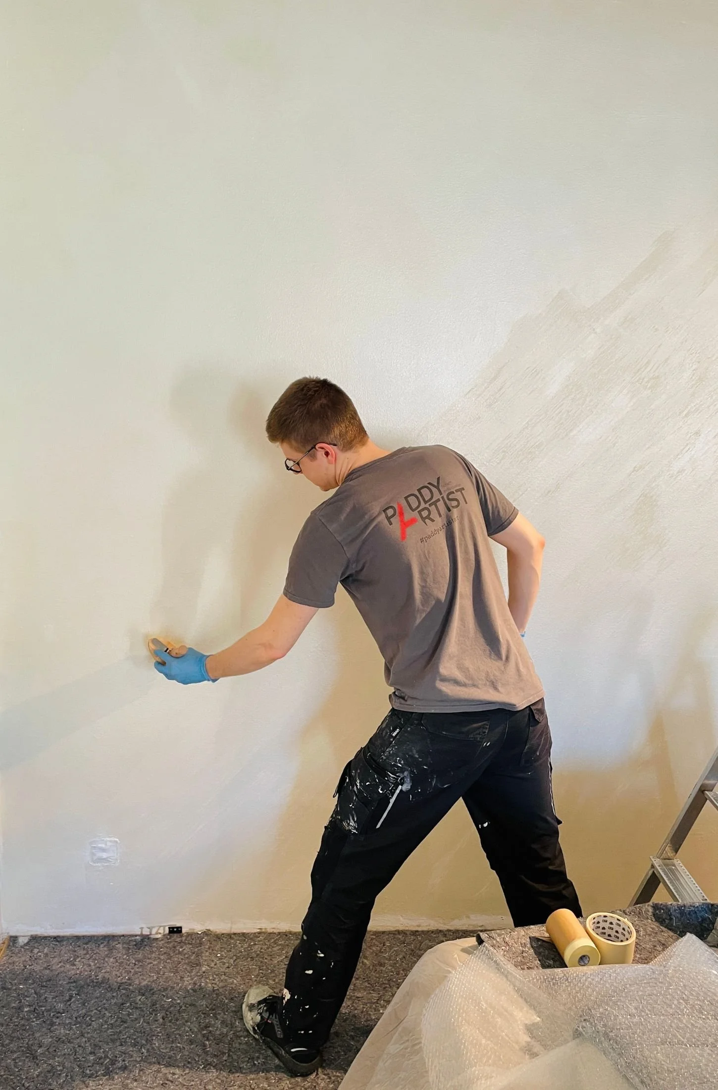 Handwerker beim Auftragen einer fugenlosen Oberfläche auf eine Innenwand