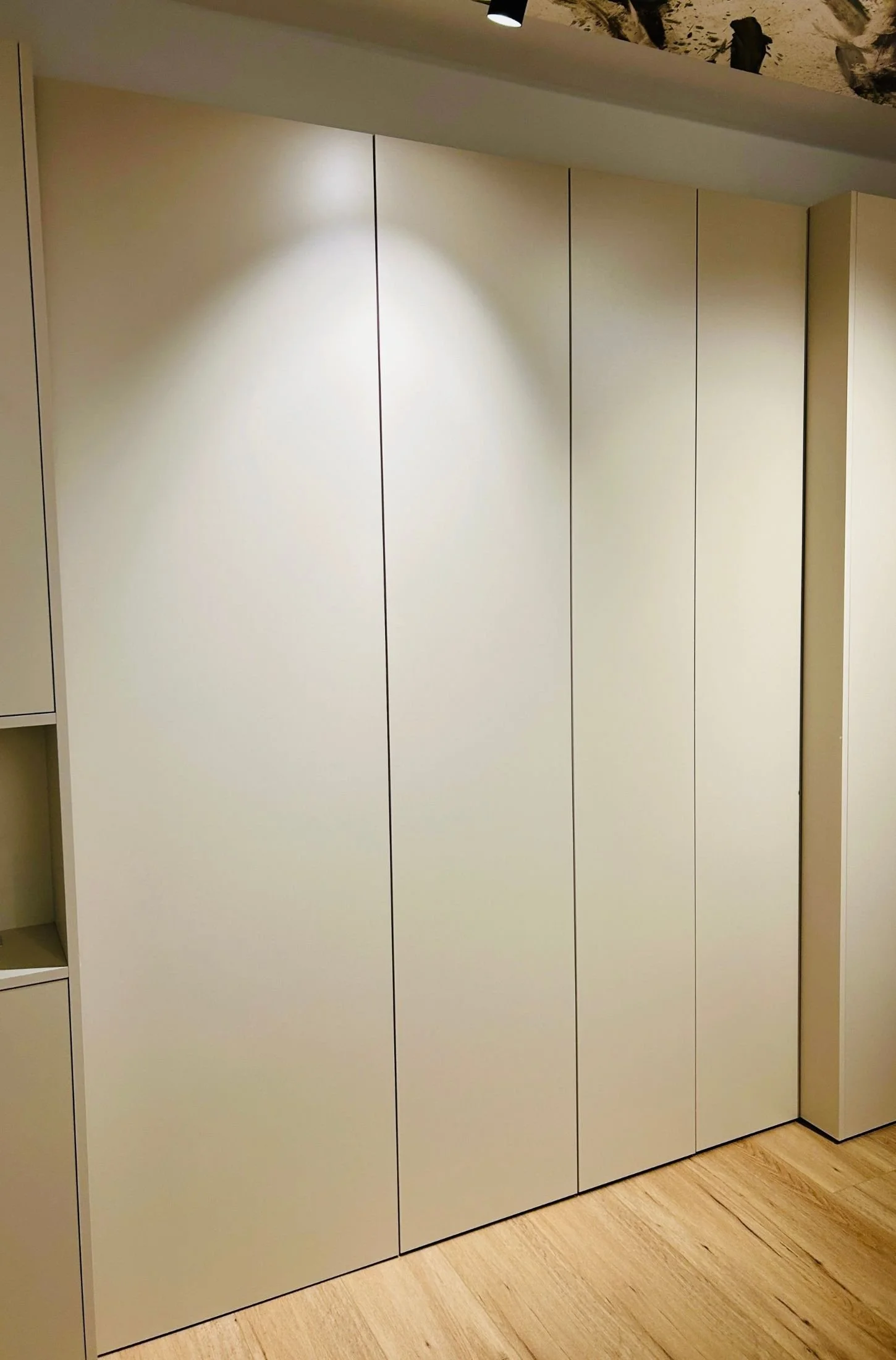 Maßgefertigter Einbauschrank mit glatten weißen Fronten bis zur Decke