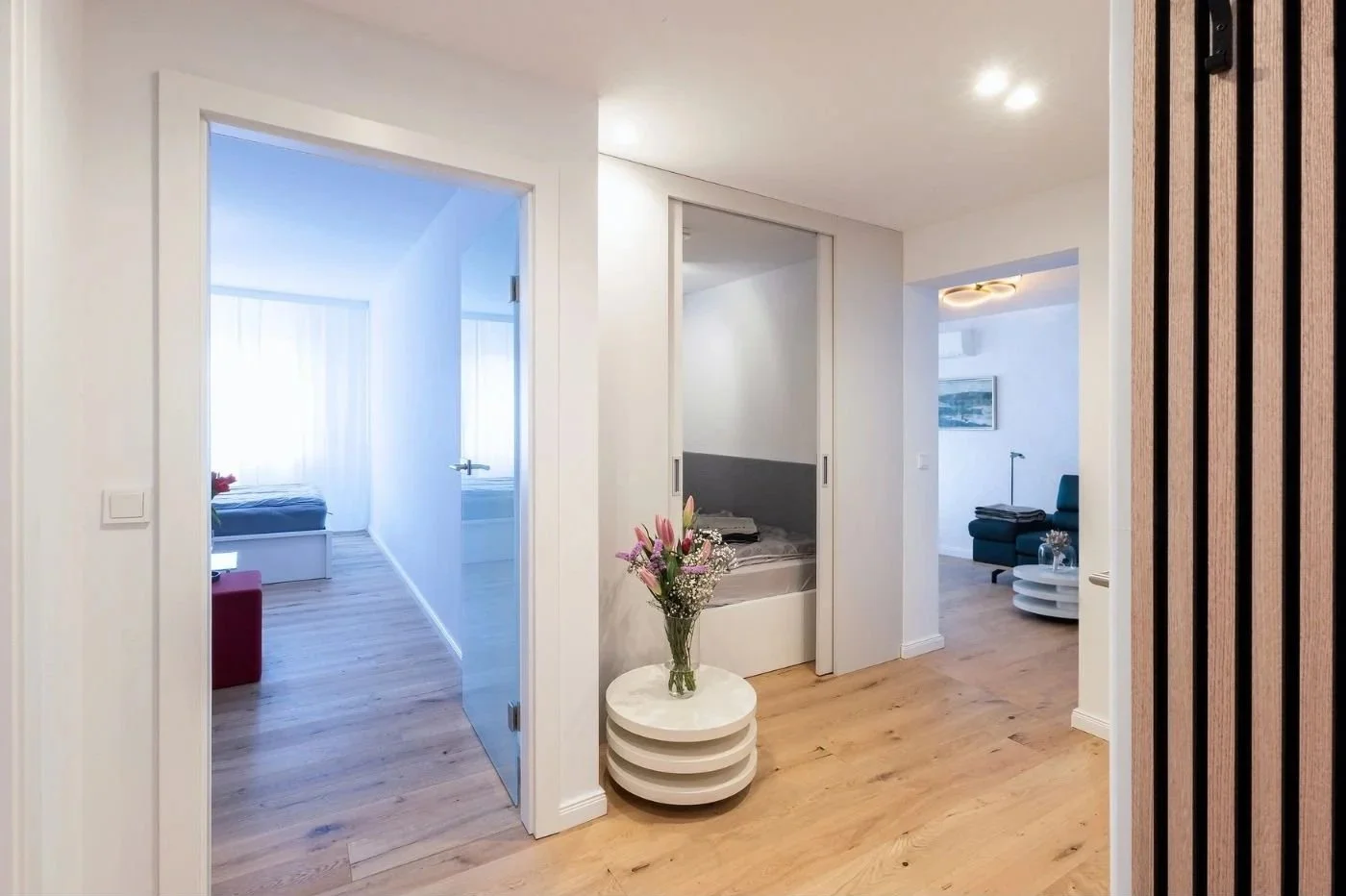 Heller Wohnungsflur mit weißem Einbauschrank und Glastür