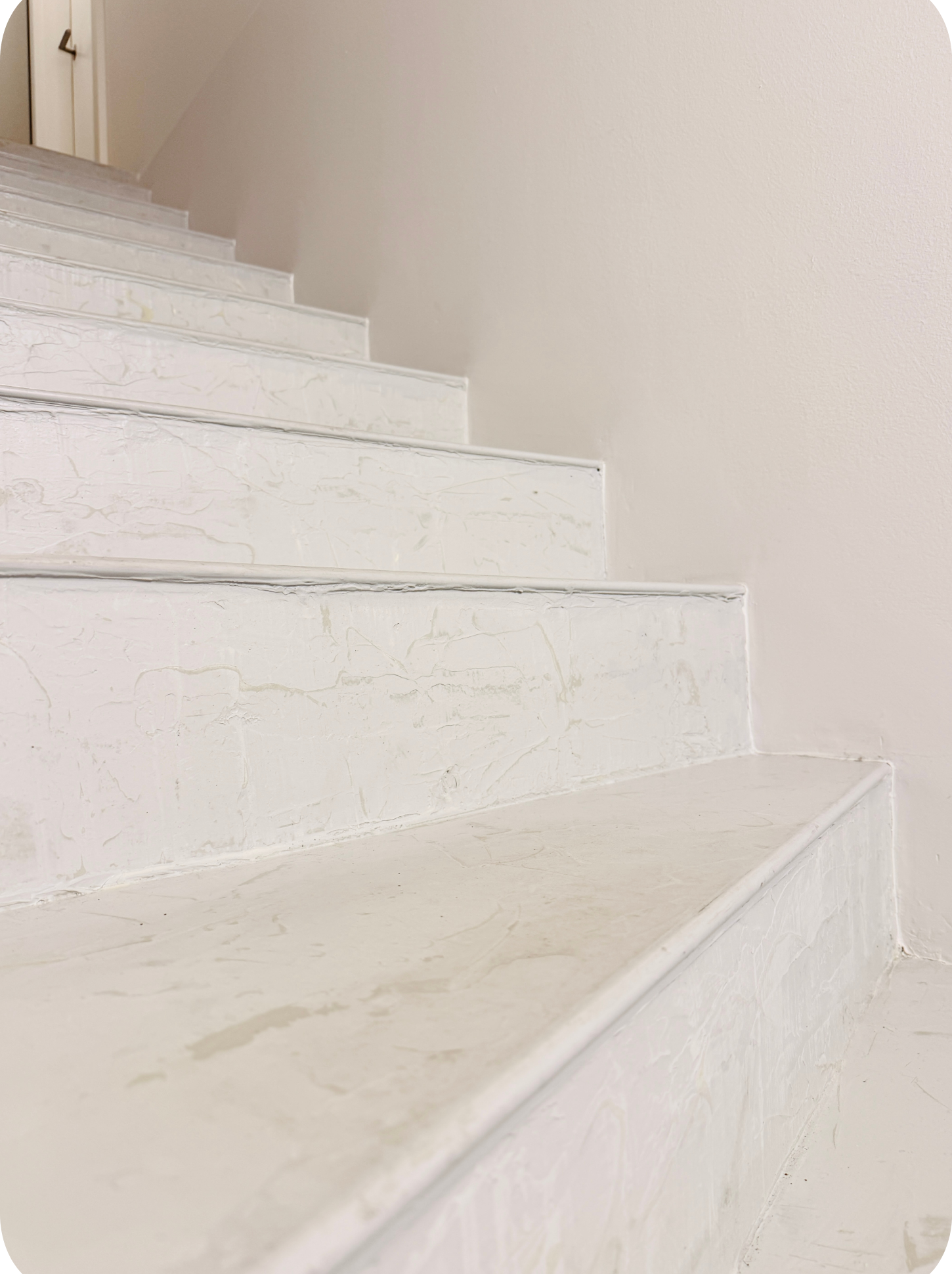 Nachher-Bild einer fugenlosen Treppe im Kellergang mit heller moderner Oberfläche nach der Umgestaltung