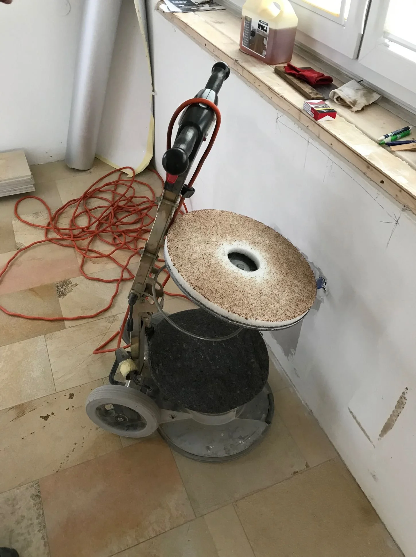 Bodenarbeiten im Wohnzimmer mit Parkett, Fliesen und Schleifmaschine während der Umgestaltung und Sanierung im Innenausbau