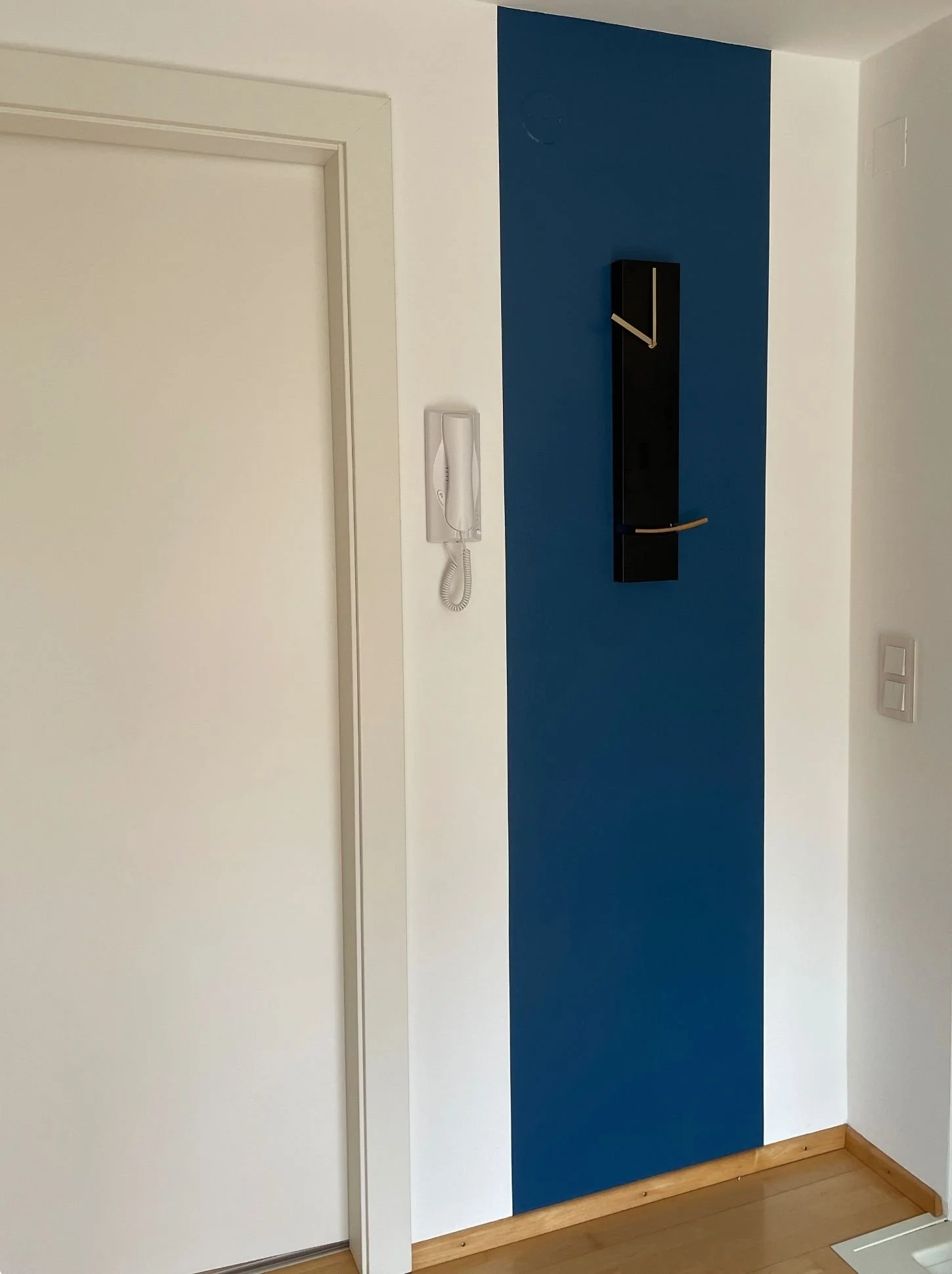 Nachher-Bild eines Vorzimmers mit kräftiger blauer Akzentwand und moderner Wandgestaltung zur optischen Aufwertung des Eingangsbereichs