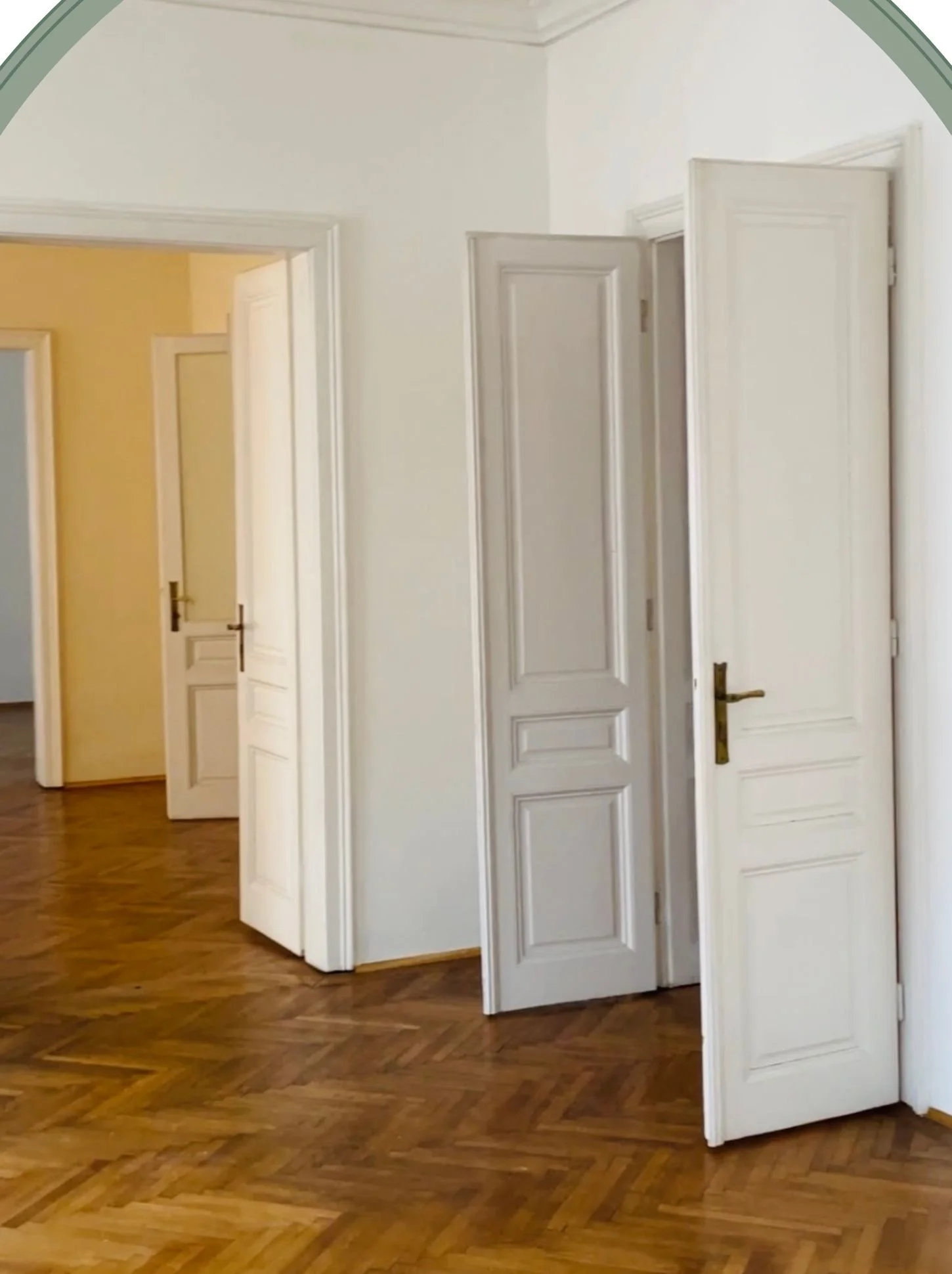 Vorher-Bild eines Altbau-Flurs mit Parkettboden und weißen Türen als Ausgangssituation vor der Raumgestaltung und Umgestaltung