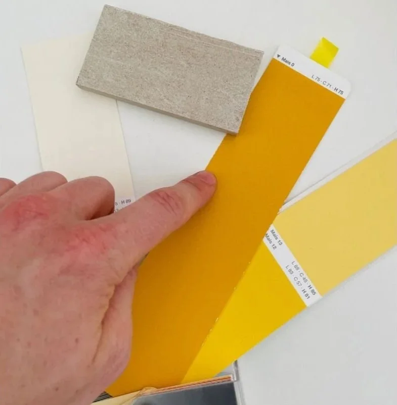 Detailaufnahme von Farbmustern in Gelbtönen zur Farbberatung und Auswahl einer passenden Wandfarbe für die Innenraumgestaltung