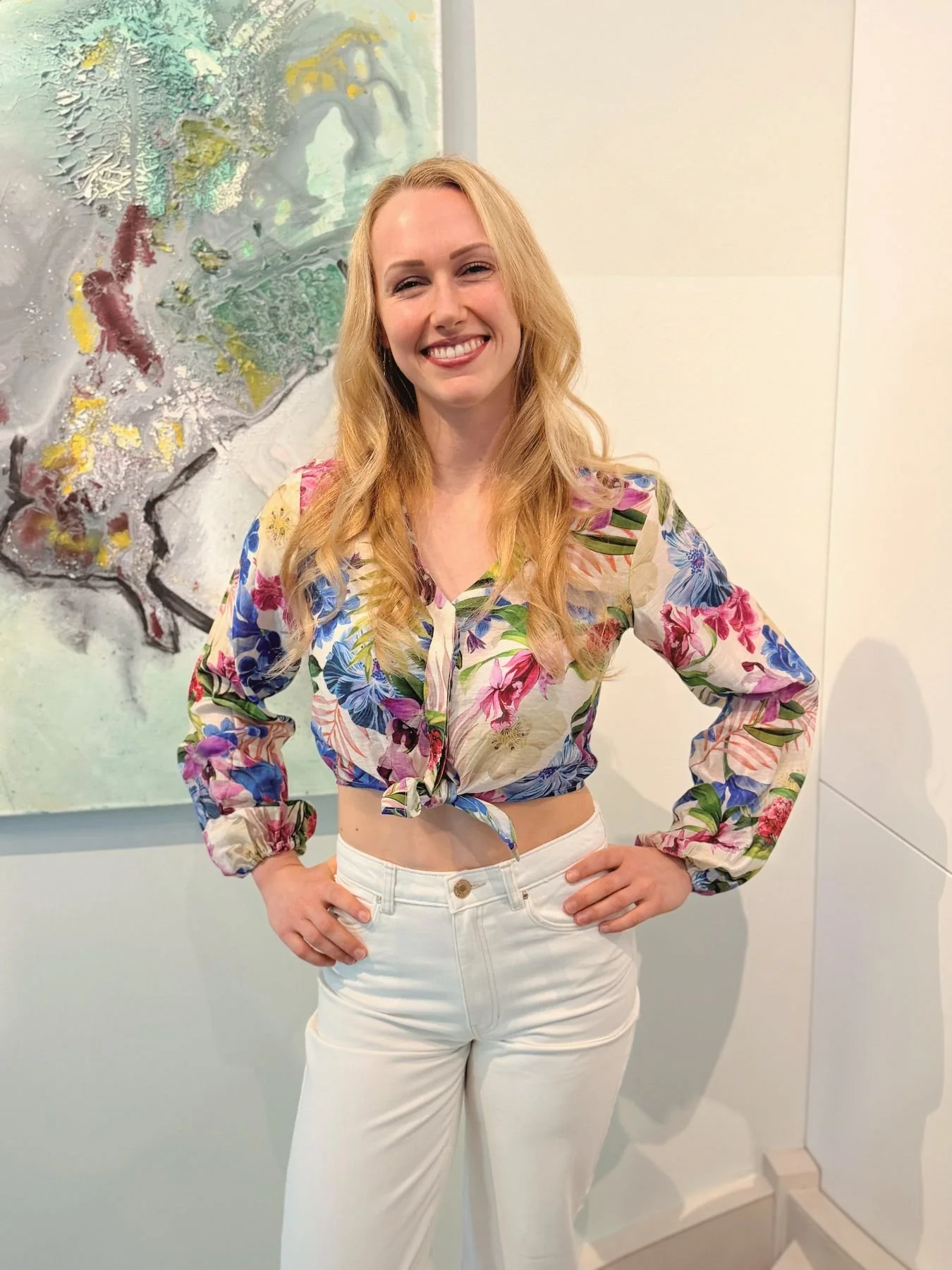 Frau in modernem, hellem Innenraum vor abstraktem Kunstwerk – persönliche Interior-Beratung und individuelle Raumgestaltung in Wien