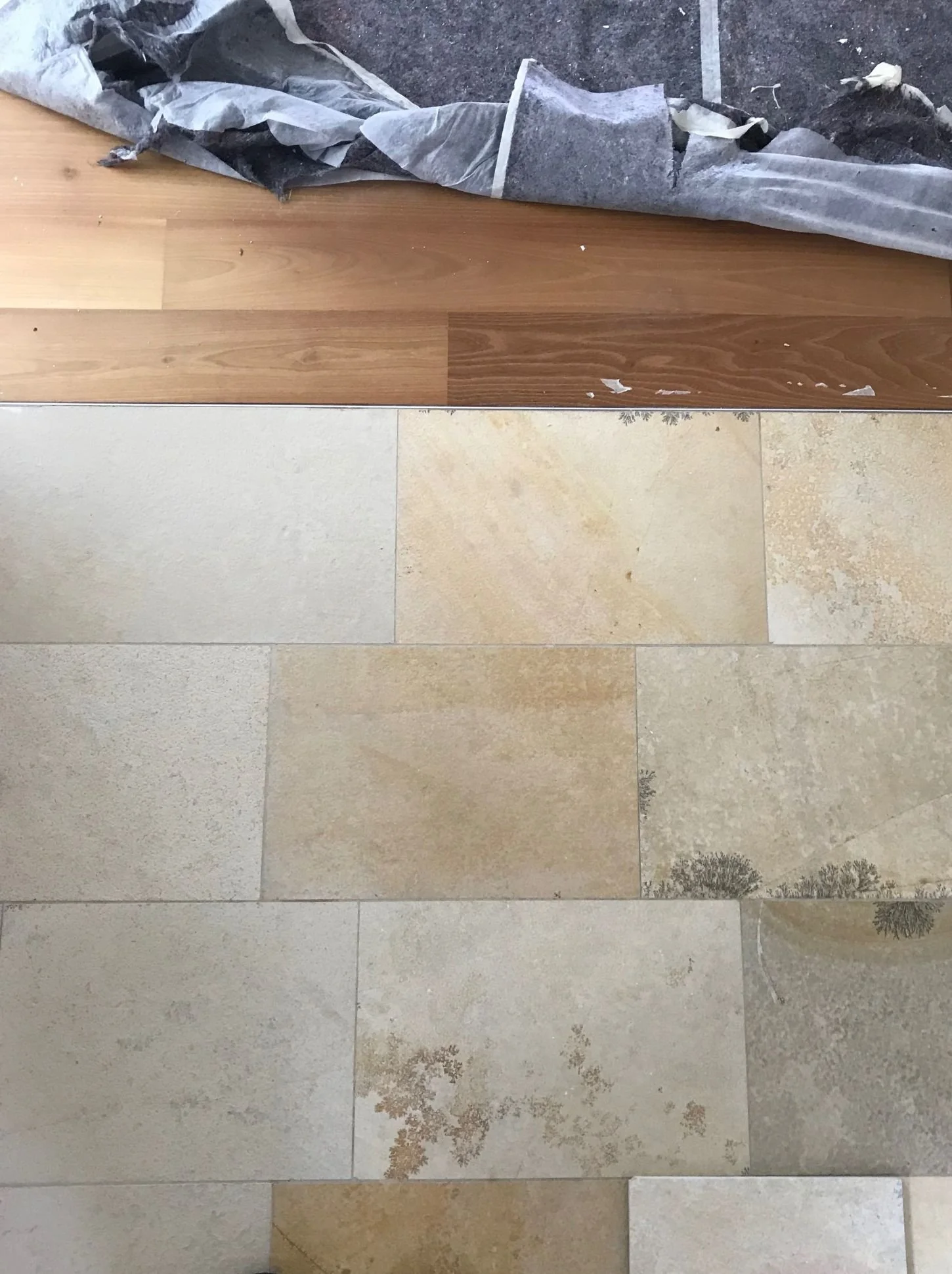 Übergang von Parkett und Fliesen im Wohnzimmer während der Umgestaltung mit sichtbaren Bodenarbeiten im Innenausbau