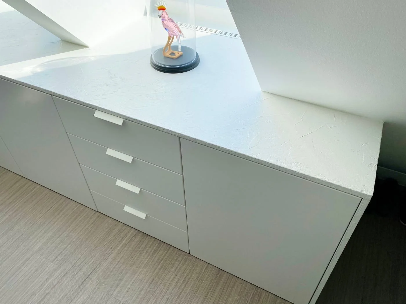 Weißer Einbauschrank mit Schubladen unter der Dachschräge, seitliche Ansicht